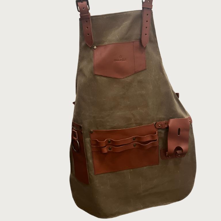 Canvas and leather apron with adjustable straps, chest pocket, and tool loops — durable stylish for grilling, crafts, or work