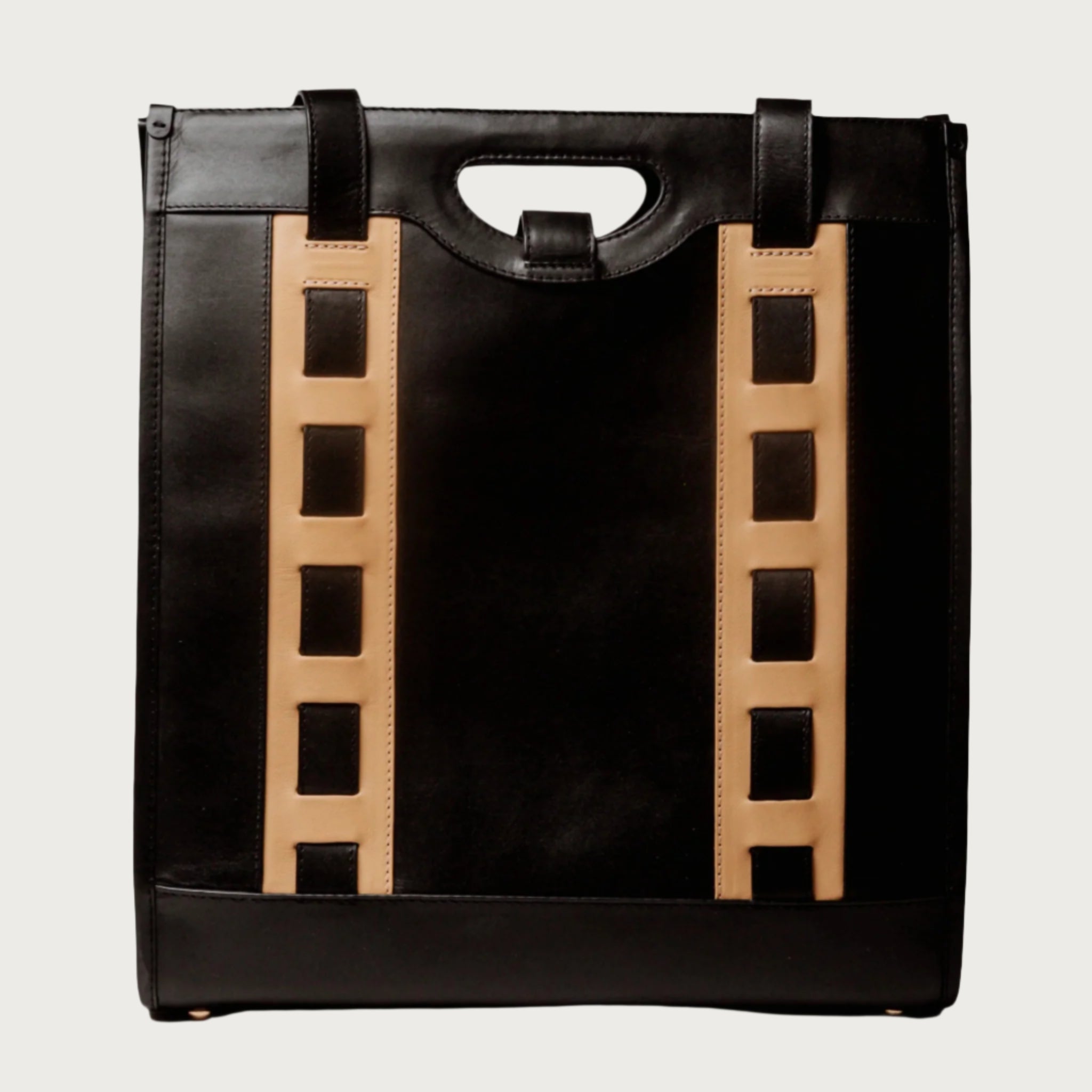 Tote bag with handwoven cane body and black leather trim, open top, structured shape, and dual handles — artisan and elegant.