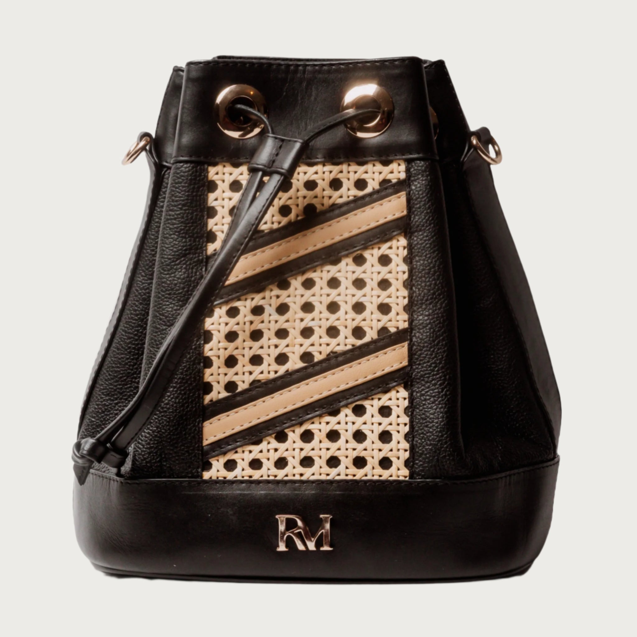 Wicker and black leather bucket bag with drawstring closure, gold hardware, inner lining, and artisan-made woven structure.
