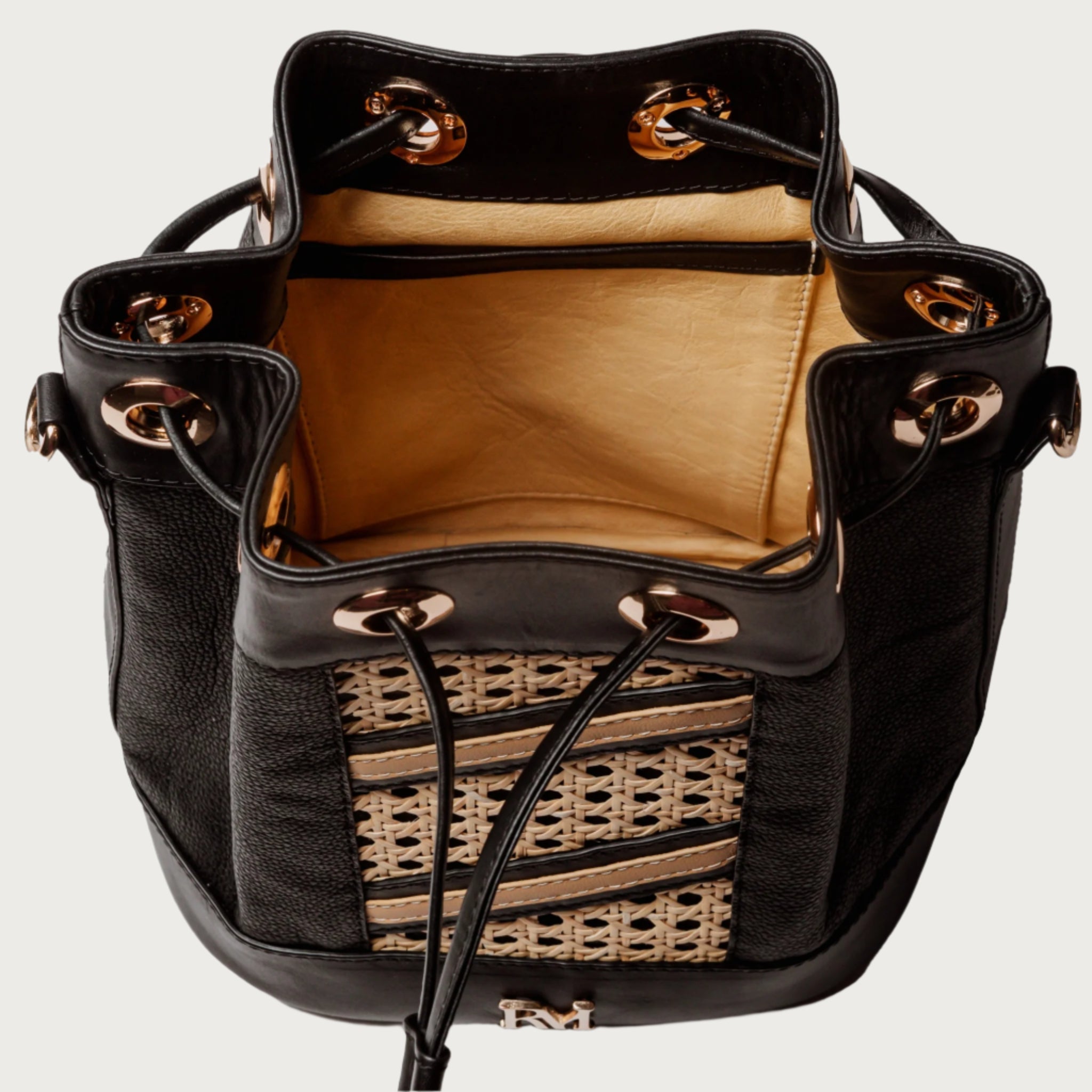 Wicker and black leather bucket bag with drawstring closure, gold hardware, inner lining, and artisan-made woven structure.