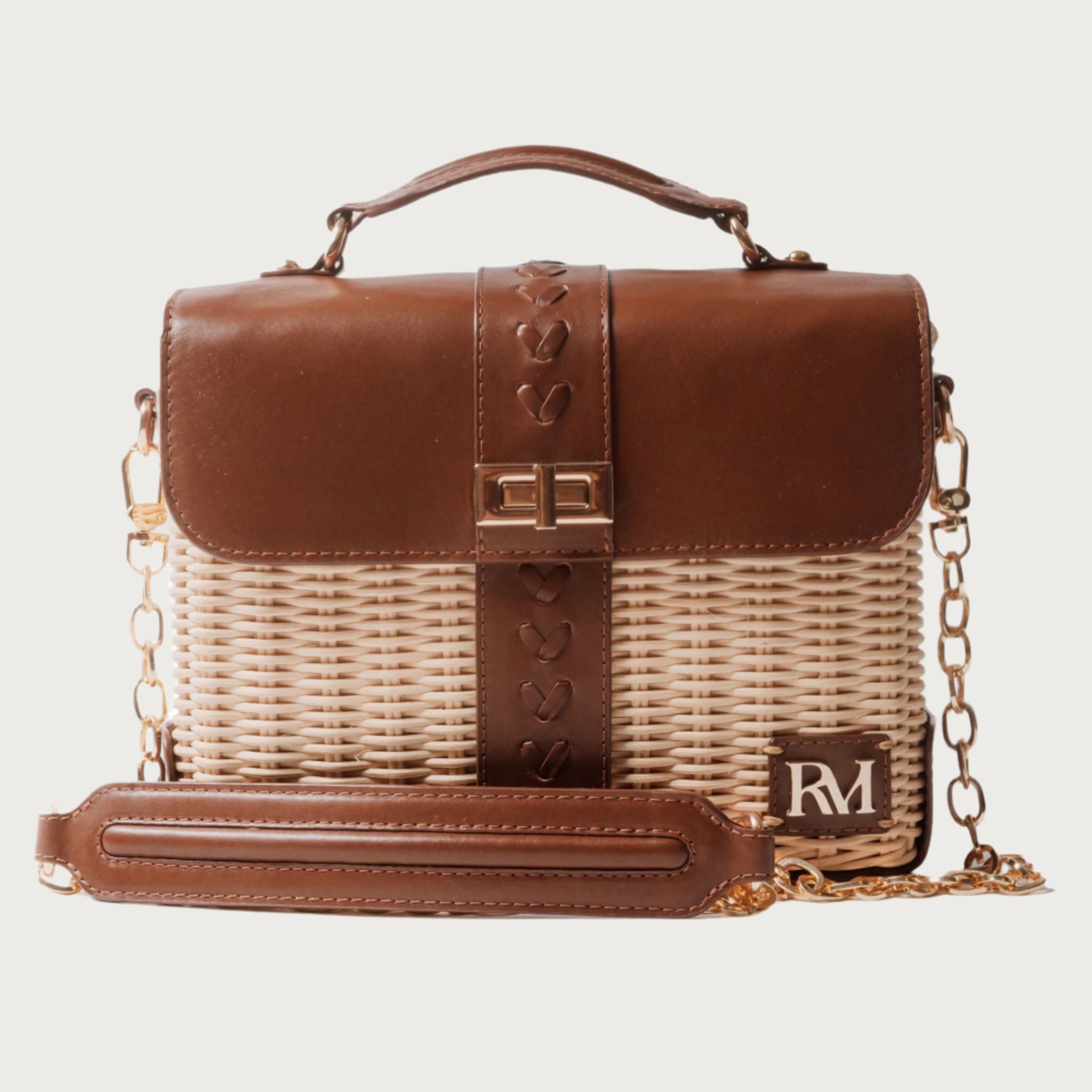 Structured handbag with woven rattan body, leather flap and trim, gold hardware, and top handle — elegant and artisan-crafted