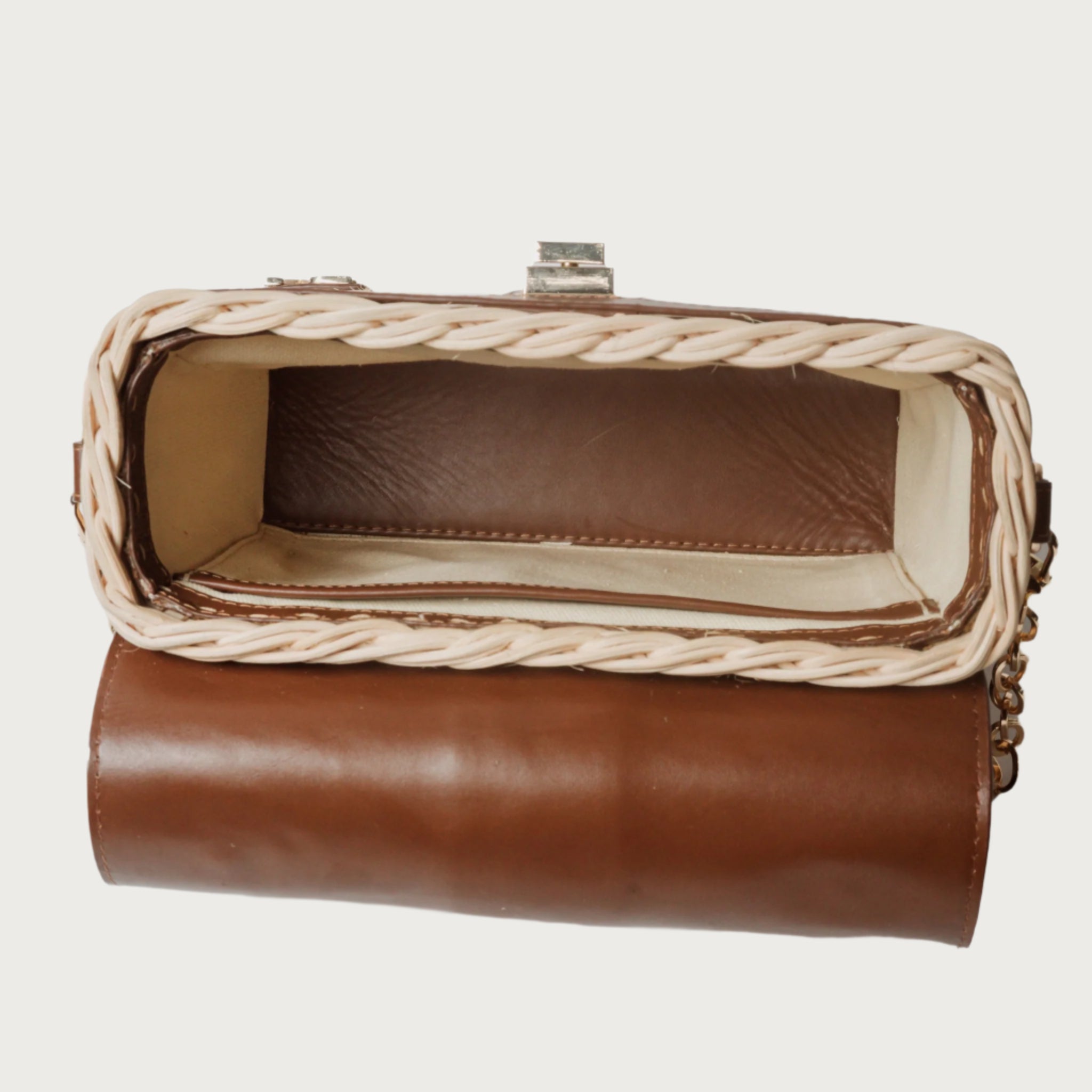 Structured handbag with woven rattan body, leather flap and trim, gold hardware, and top handle — elegant and artisan-crafted