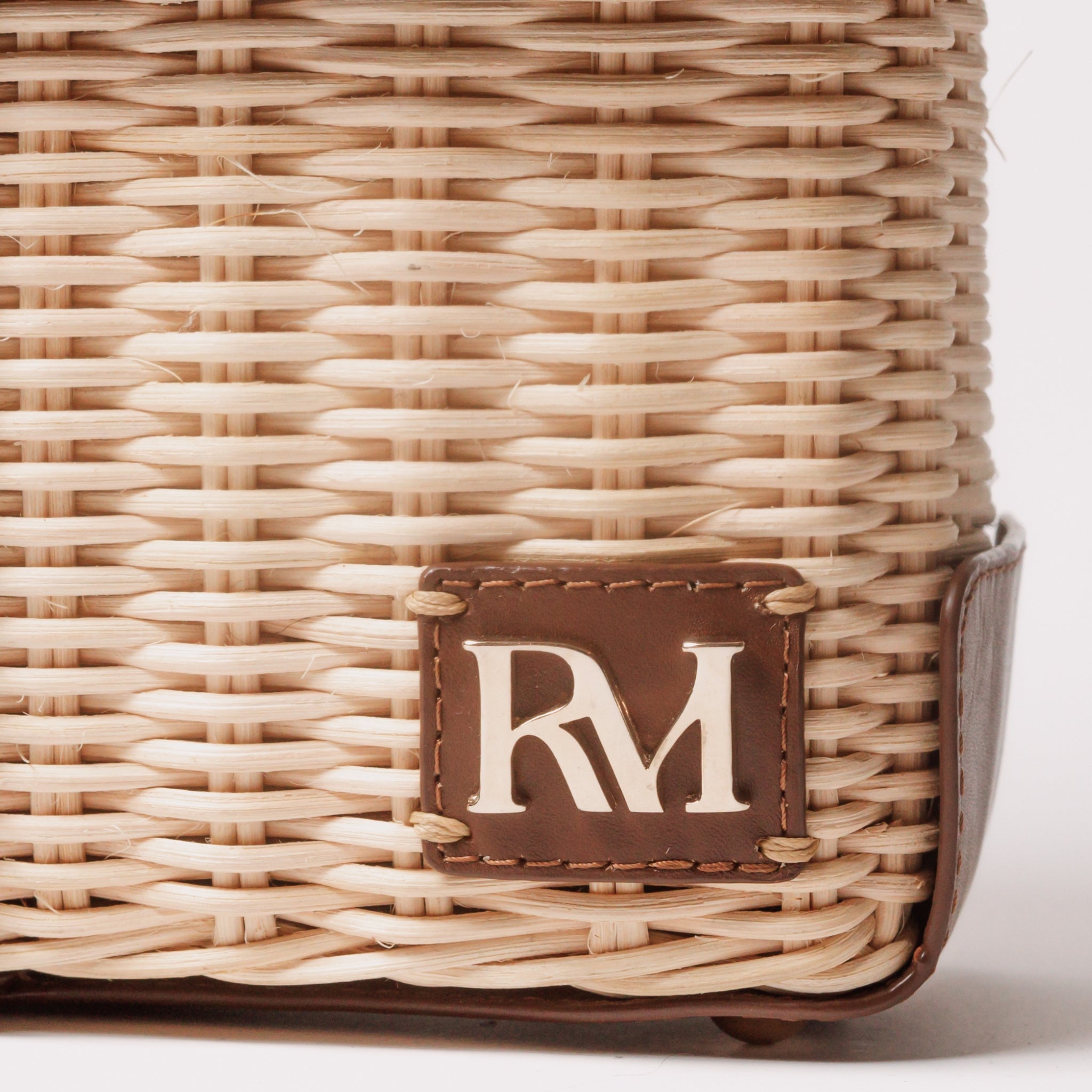 Structured handbag with woven rattan body, leather flap and trim, gold hardware, and top handle — elegant and artisan-crafted