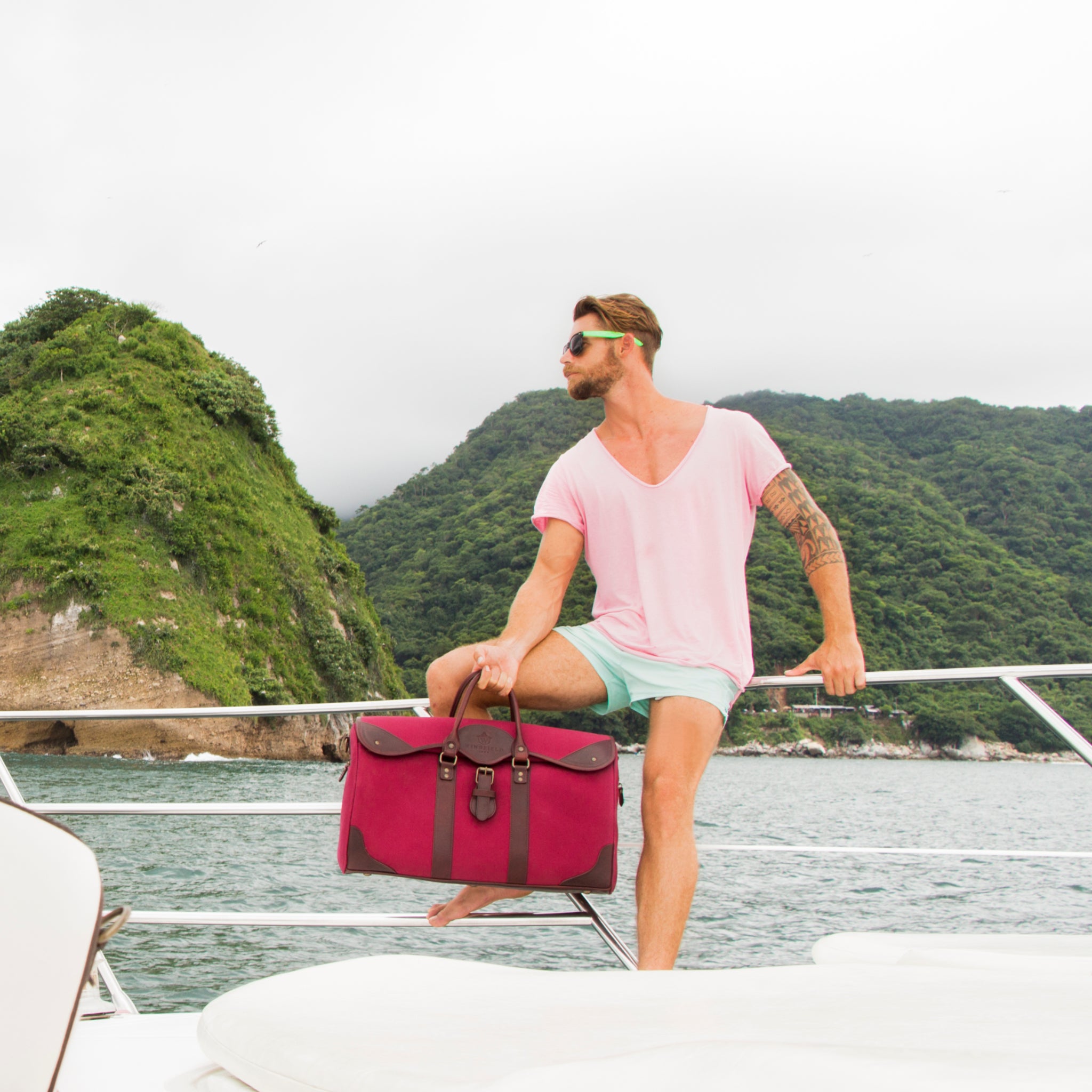 Large canvas and leather duffel bag with top handles, adjustable shoulder strap, leather trim, and zip closure, for travel