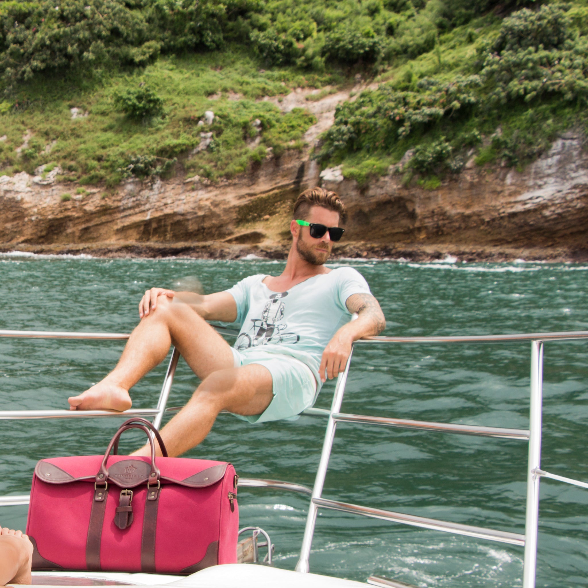 Large canvas and leather duffel bag with top handles, adjustable shoulder strap, leather trim, and zip closure, for travel