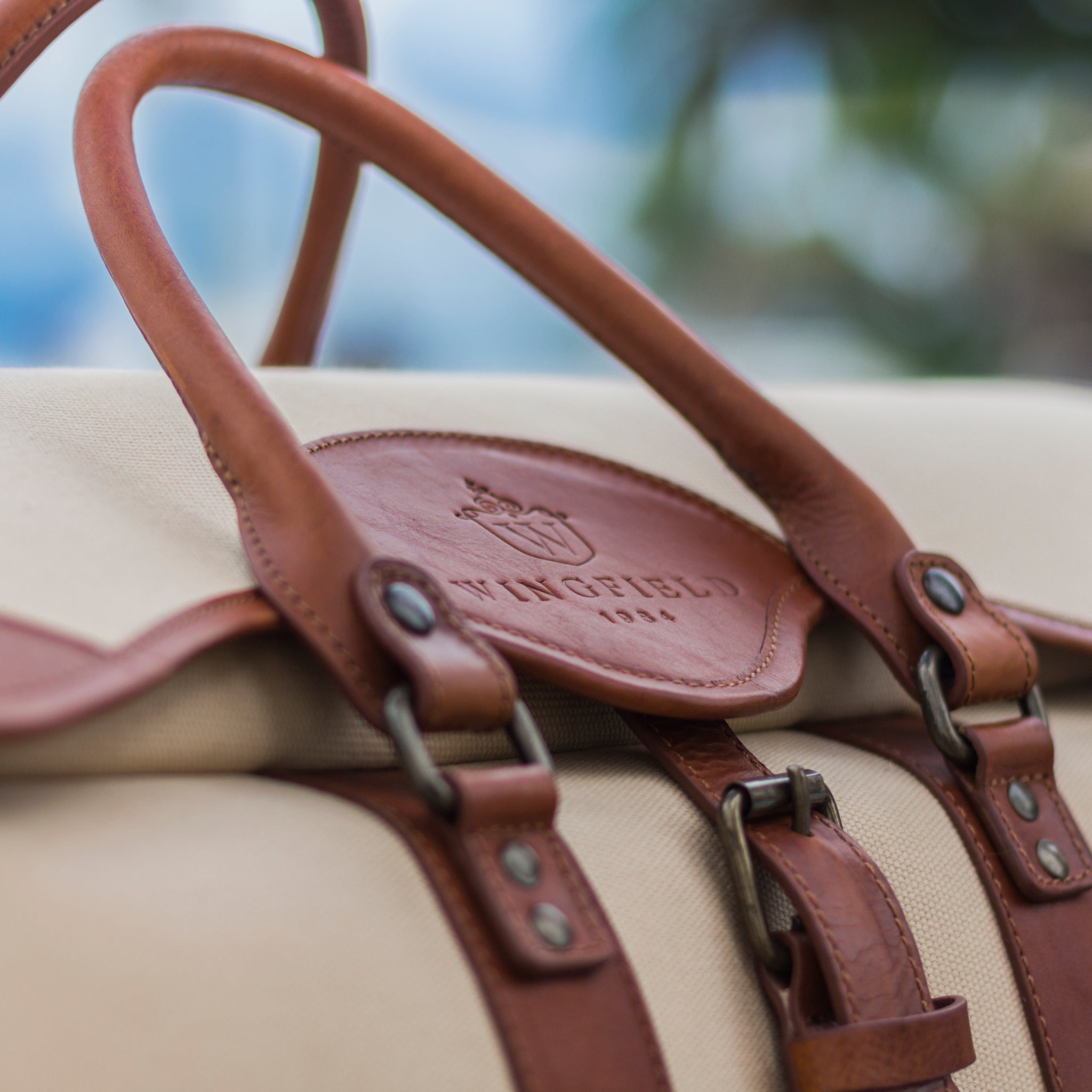 Large canvas and leather duffel bag with top handles, adjustable shoulder strap, leather trim, and zip closure, for travel