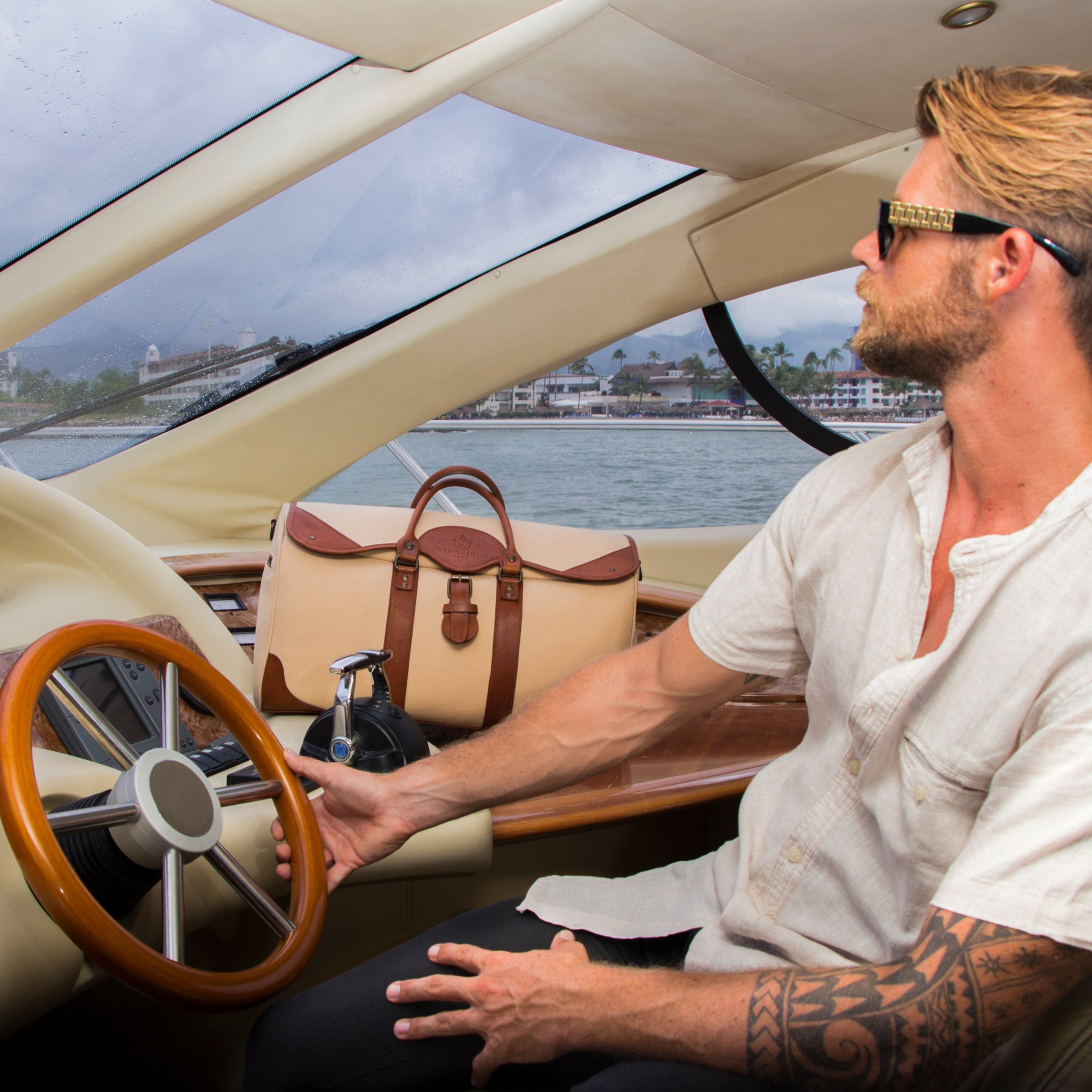 Large canvas and leather duffel bag with top handles, adjustable shoulder strap, leather trim, and zip closure, for travel