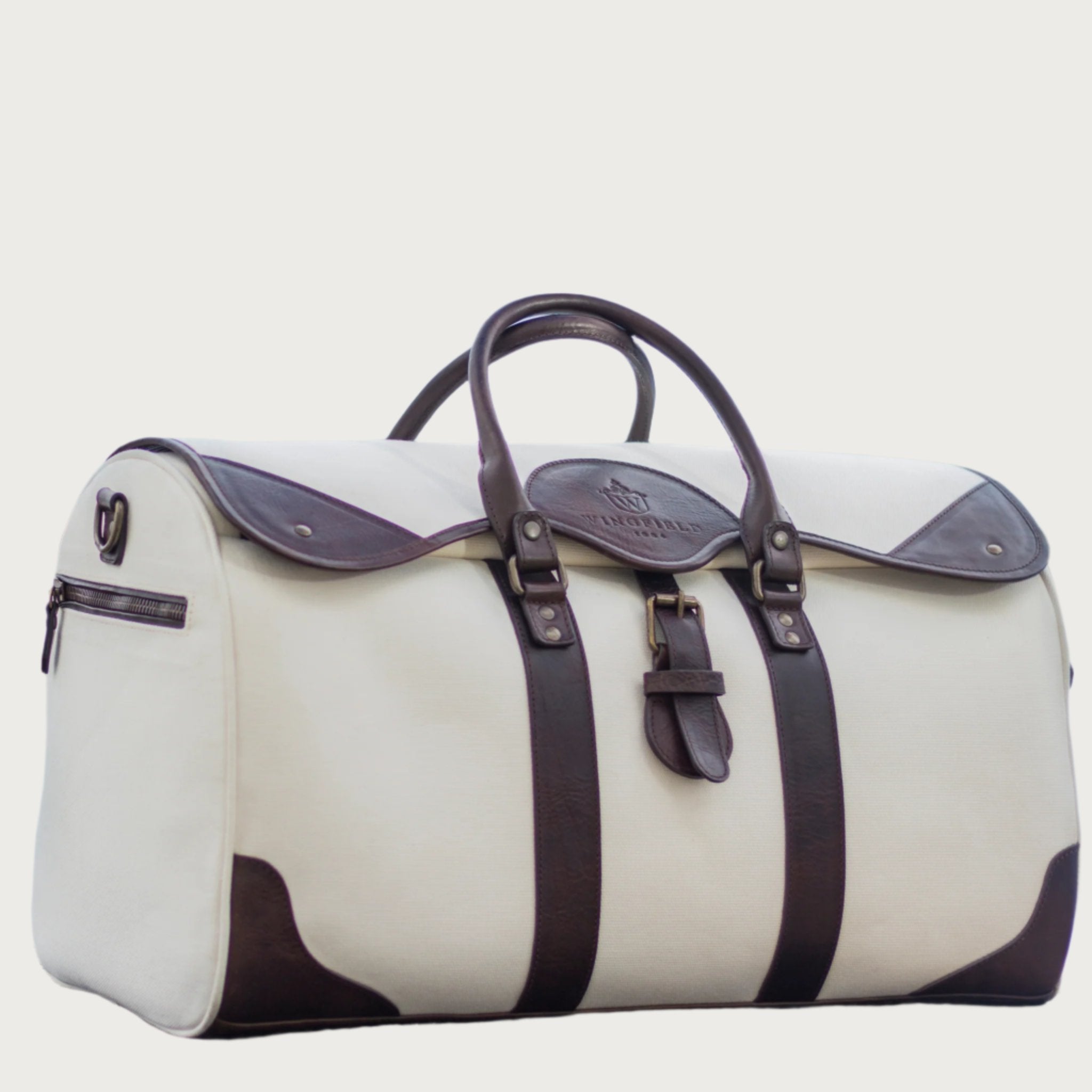 Large canvas and leather duffel bag with top handles, adjustable shoulder strap, leather trim, and zip closure, for travel