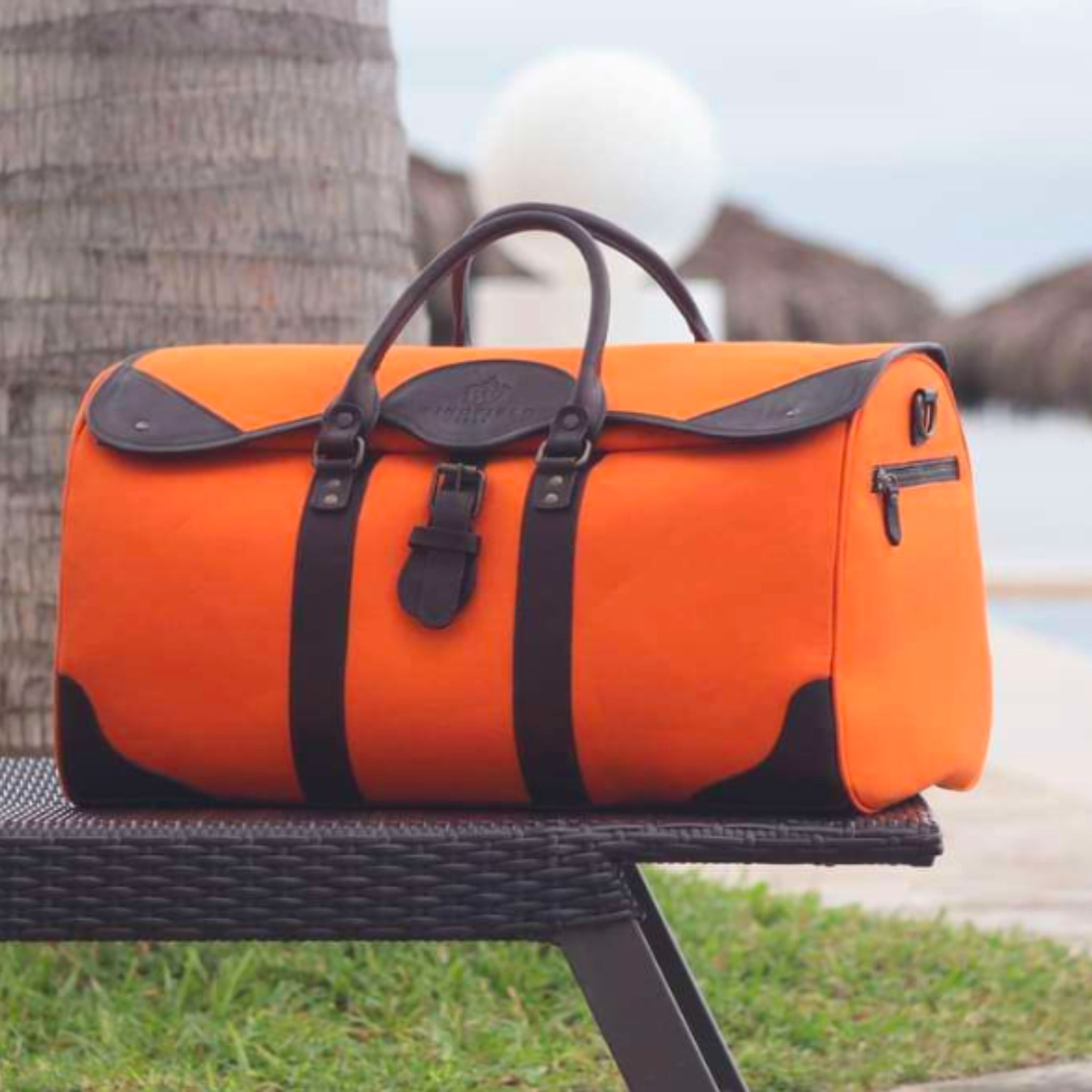 Large canvas and leather duffel bag with top handles, adjustable shoulder strap, leather trim, and zip closure, for travel