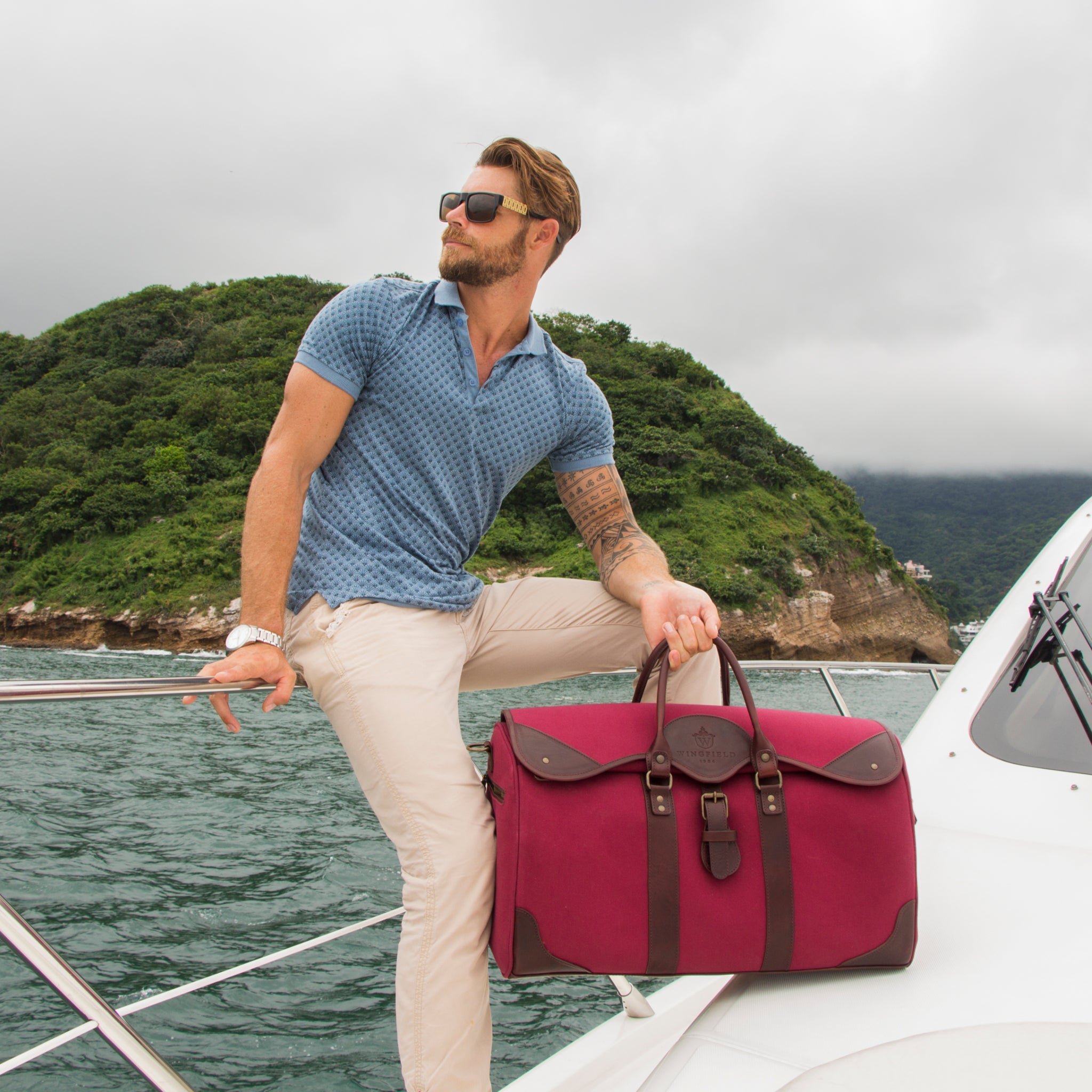 Large canvas and leather duffel bag with top handles, adjustable shoulder strap, leather trim, and zip closure, for travel