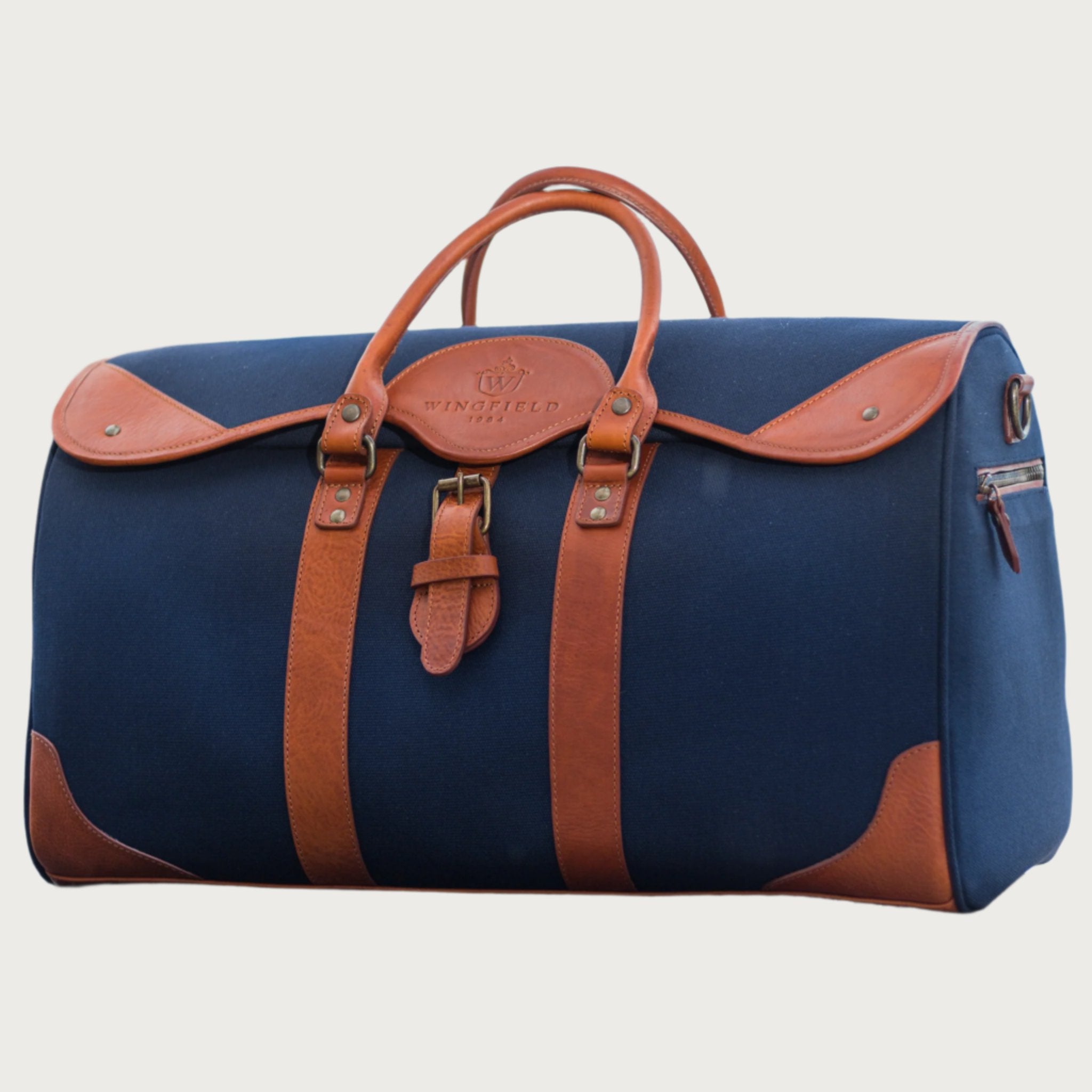 Large canvas and leather duffel bag with top handles, adjustable shoulder strap, leather trim, and zip closure, for travel