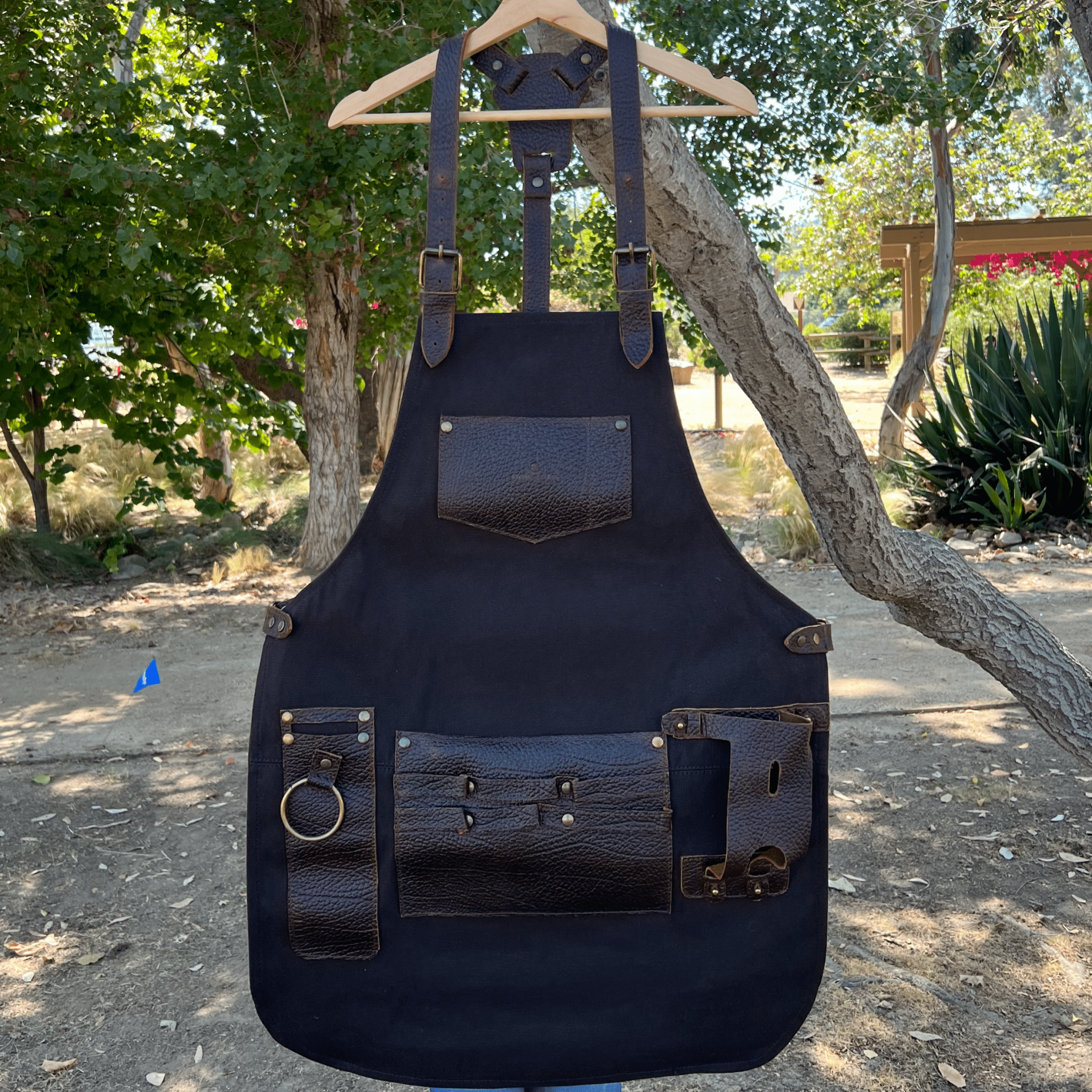 Canvas and leather apron with adjustable straps, chest pocket, and tool loops — durable stylish for grilling, crafts, or work
