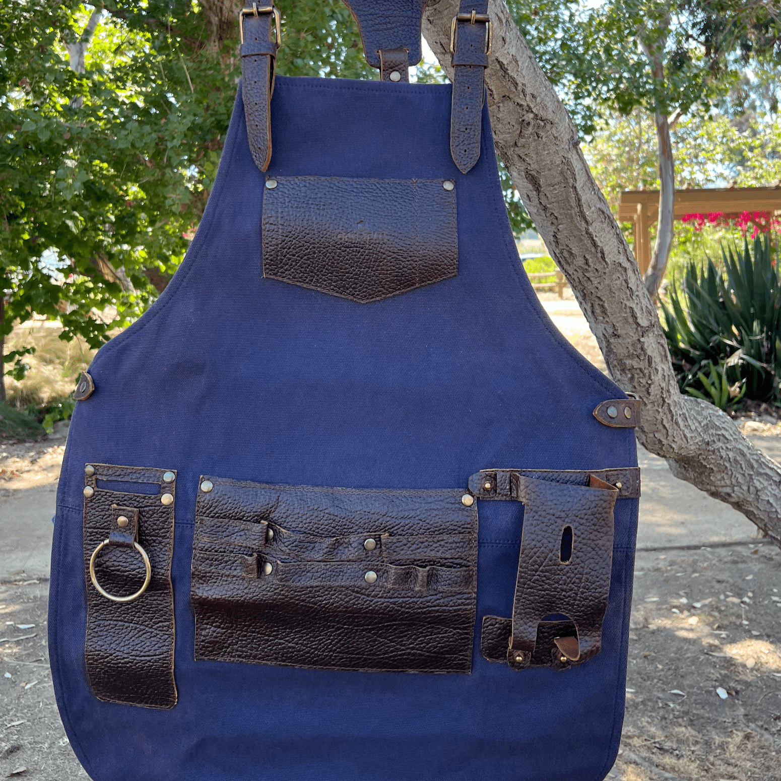 Canvas and leather apron with adjustable straps, chest pocket, and tool loops — durable stylish for grilling, crafts, or work