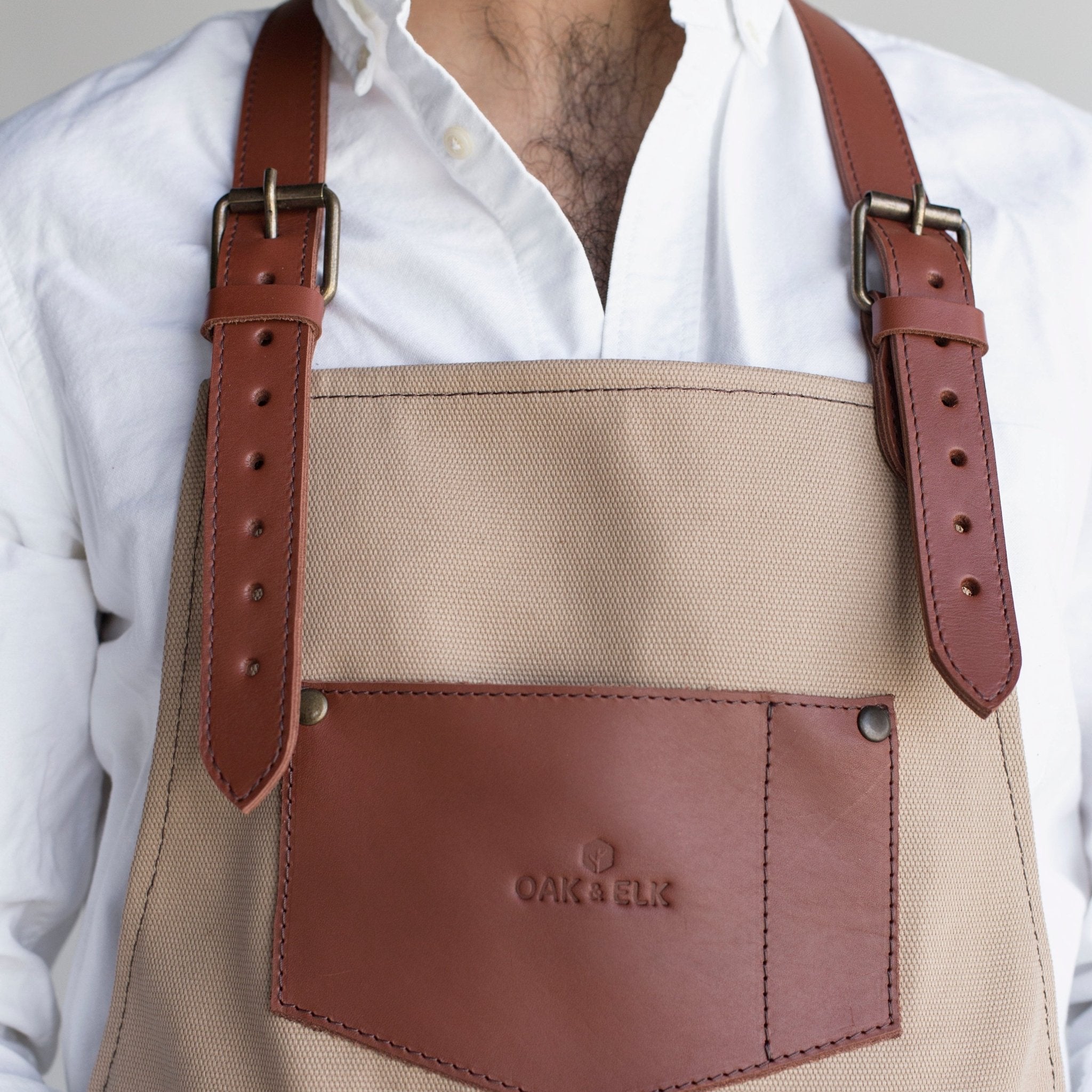 Canvas and leather apron with adjustable straps, chest pocket, and tool loops — durable stylish for grilling, crafts, or work