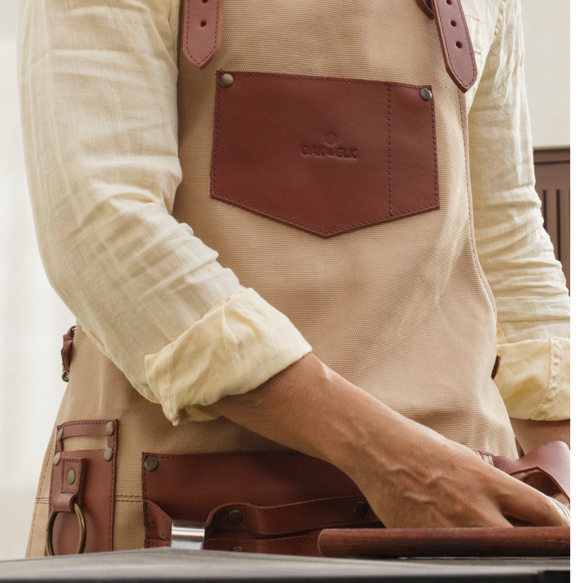 Canvas and leather apron with adjustable straps, chest pocket, and tool loops — durable stylish for grilling, crafts, or work