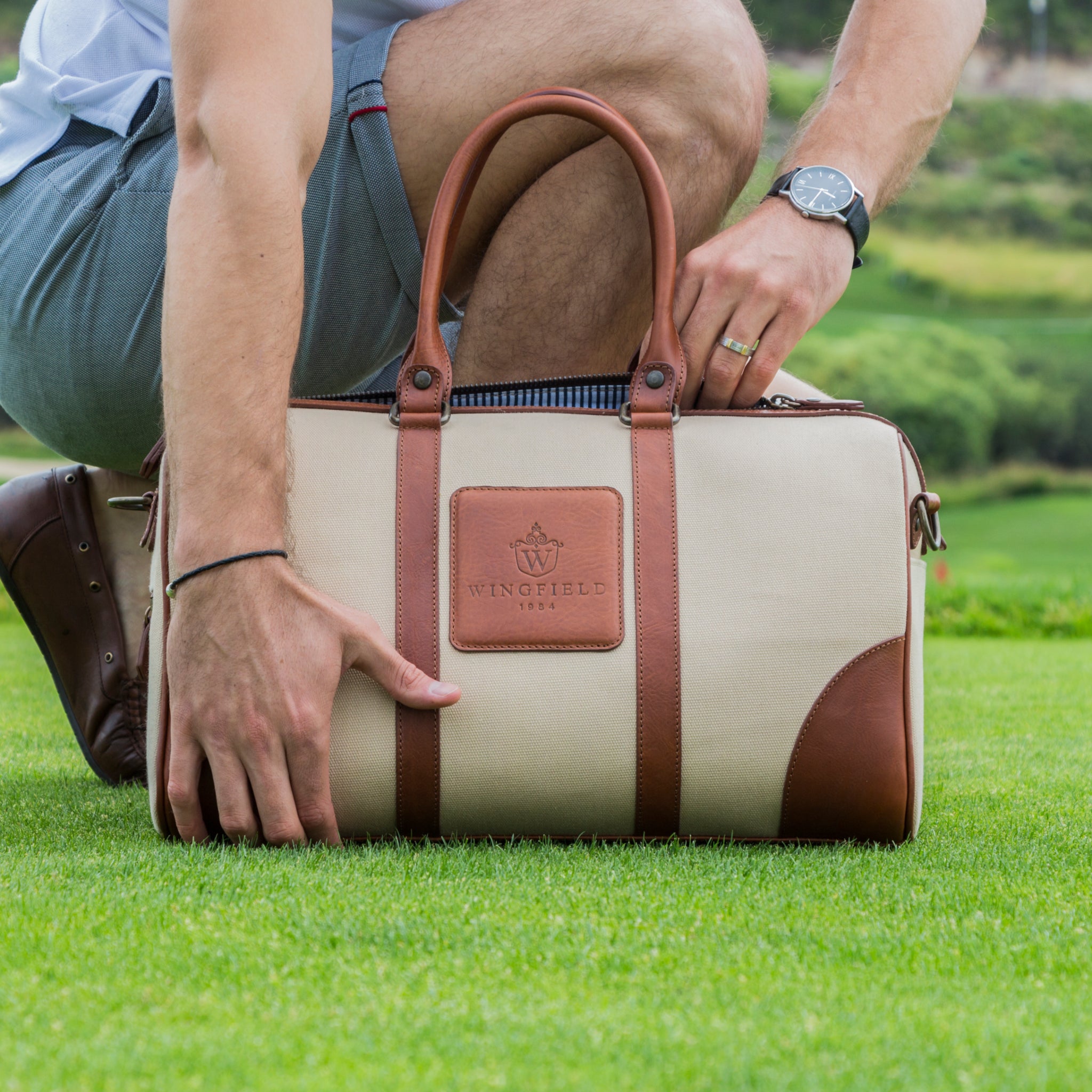 Compact canvas and leather duffel bag with top handles, adjustable shoulder strap, leather accents, zip closure travel ready