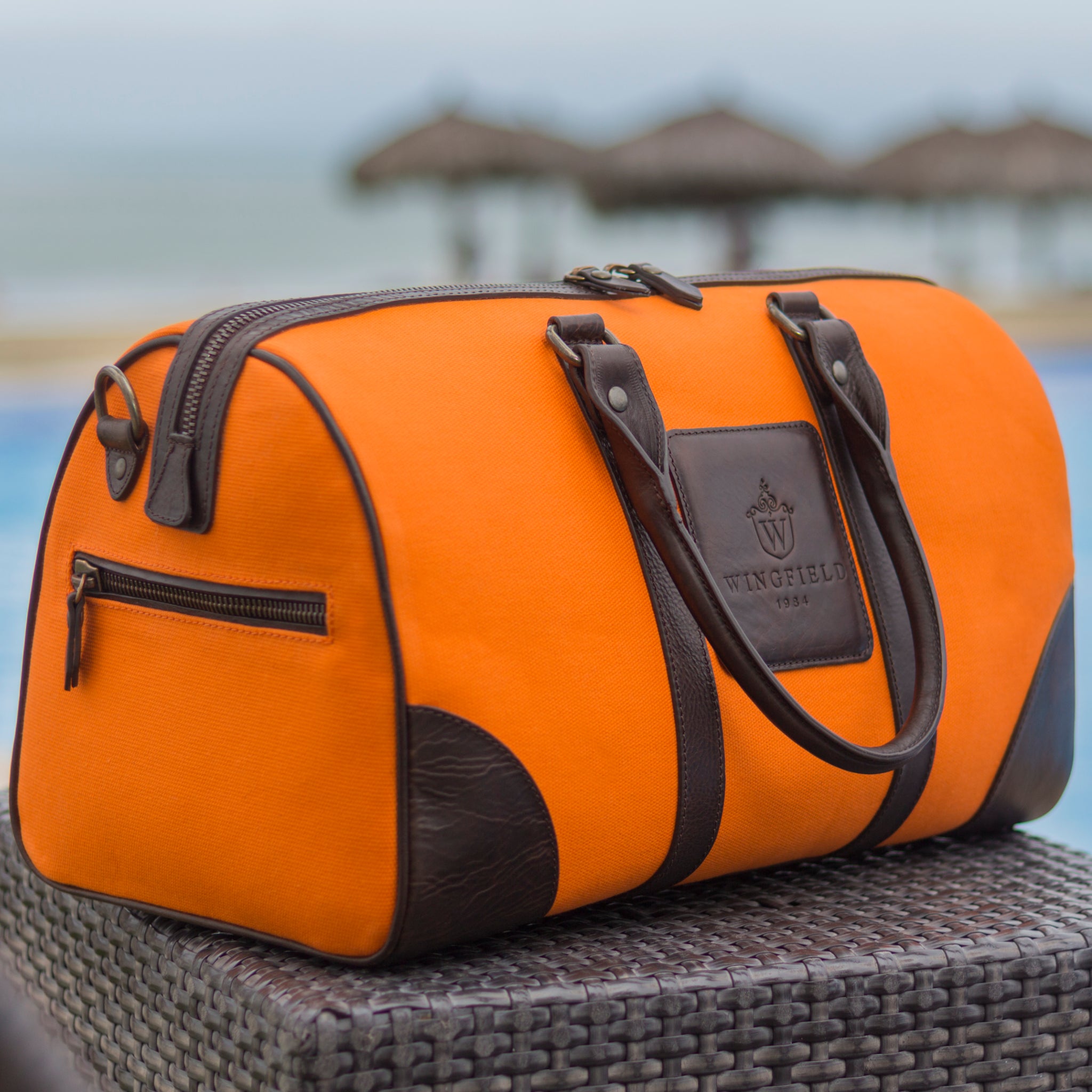 Compact canvas and leather duffel bag with top handles, adjustable shoulder strap, leather accents, zip closure travel ready