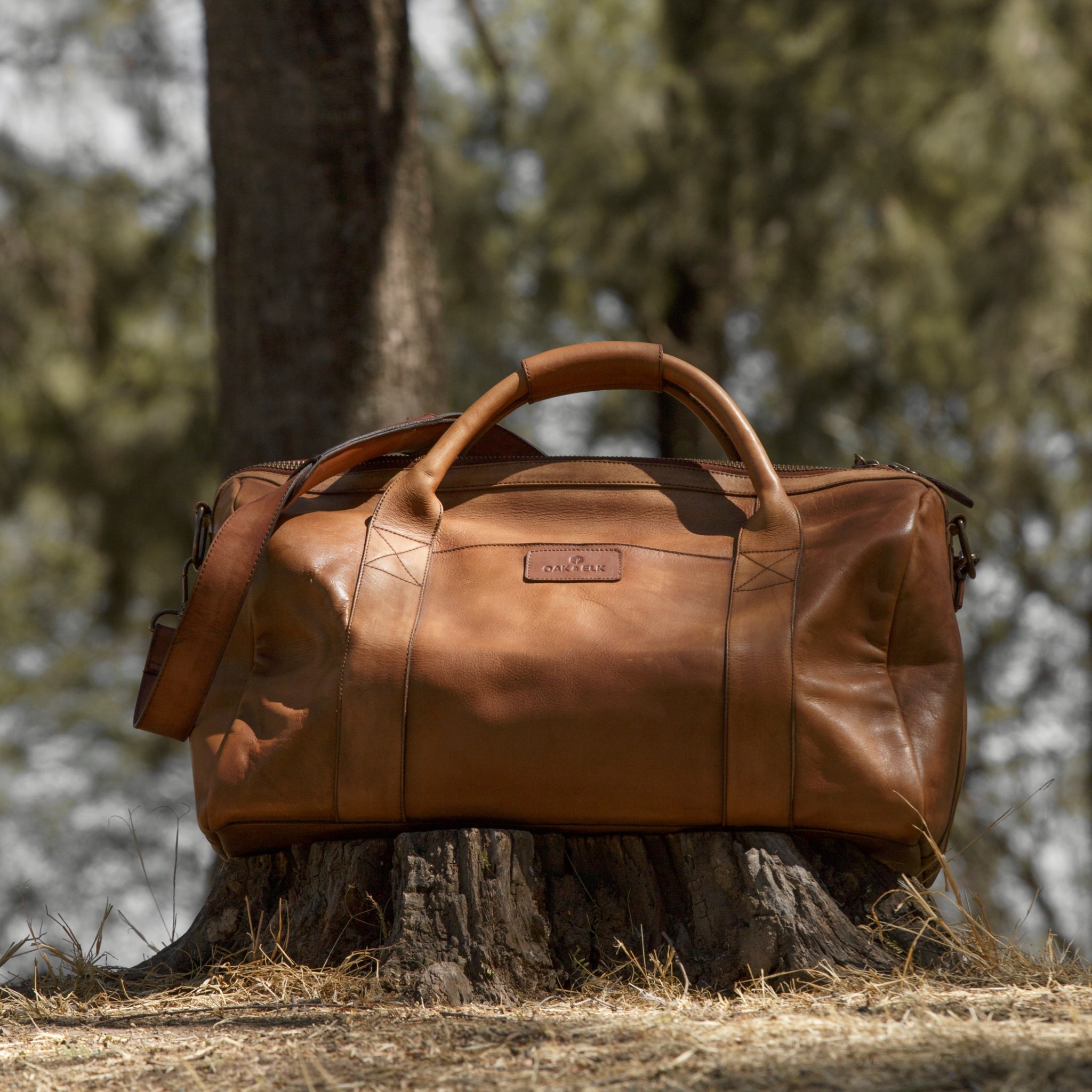 Leather duffel bag made of top-grain leather with smooth zipper, structured body, interior pockets, and adjustable strap