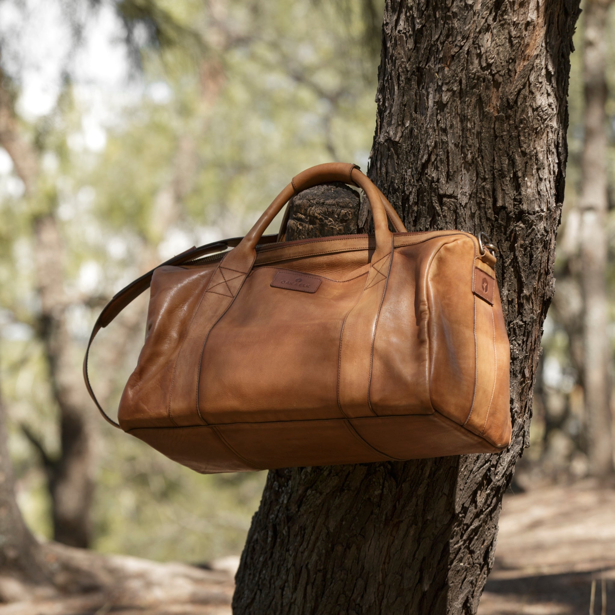 Leather duffel bag made of top-grain leather with smooth zipper, structured body, interior pockets, and adjustable strap