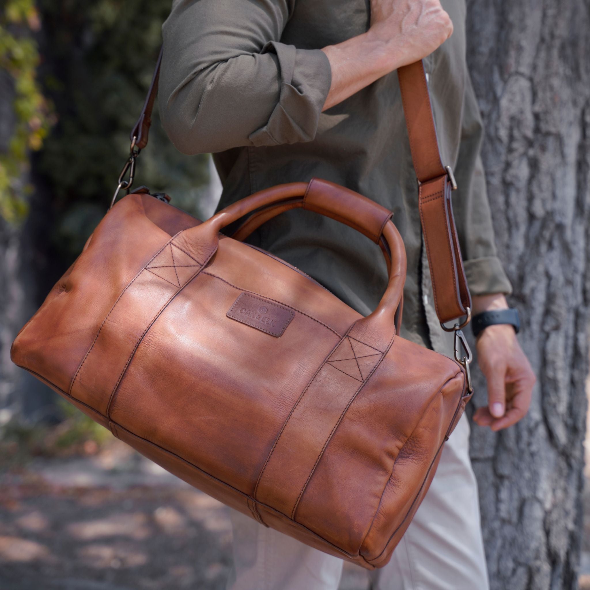 Leather duffel bag made of top-grain leather with smooth zipper, structured body, interior pockets, and adjustable strap