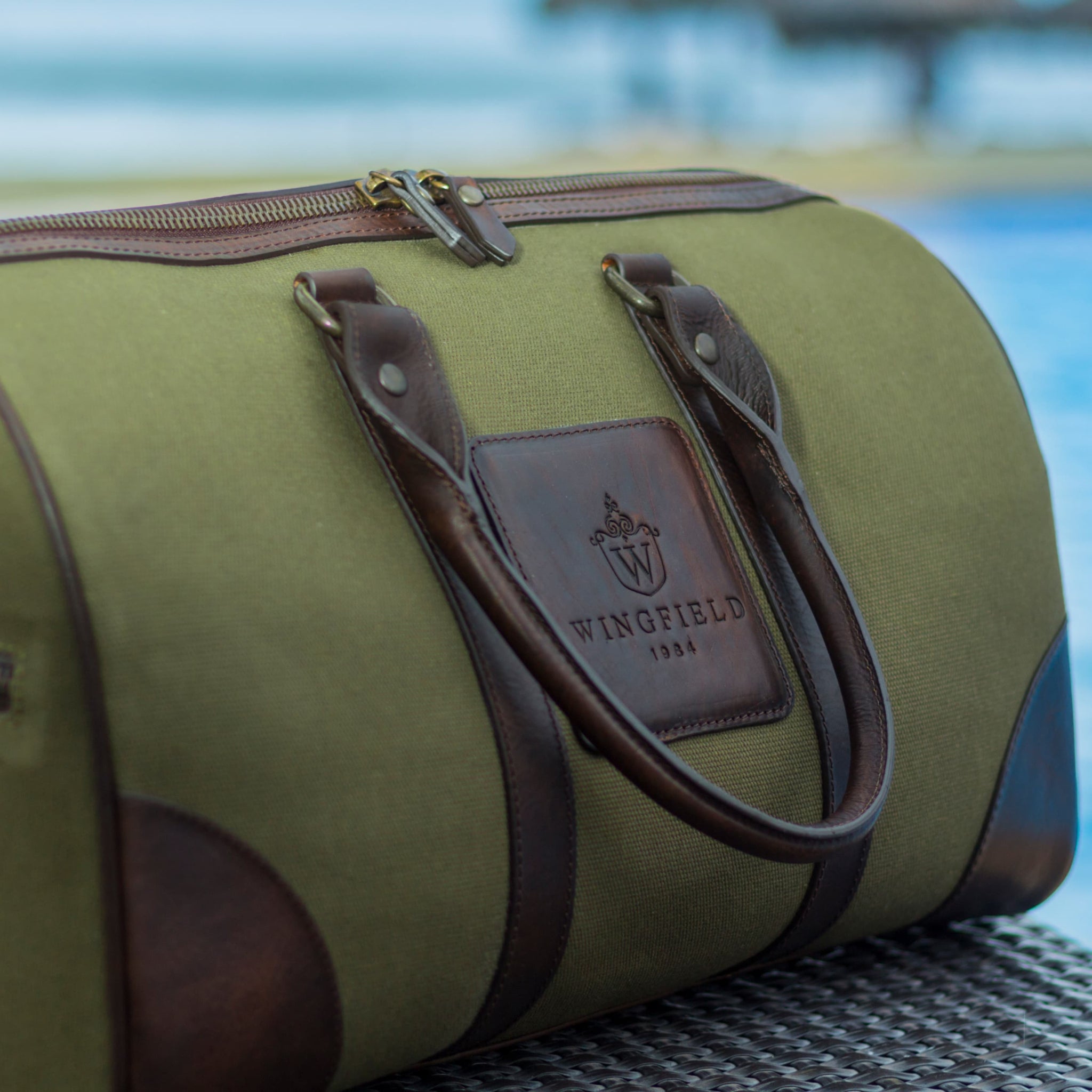 Compact canvas and leather duffel bag with top handles, adjustable shoulder strap, leather accents, zip closure travel ready