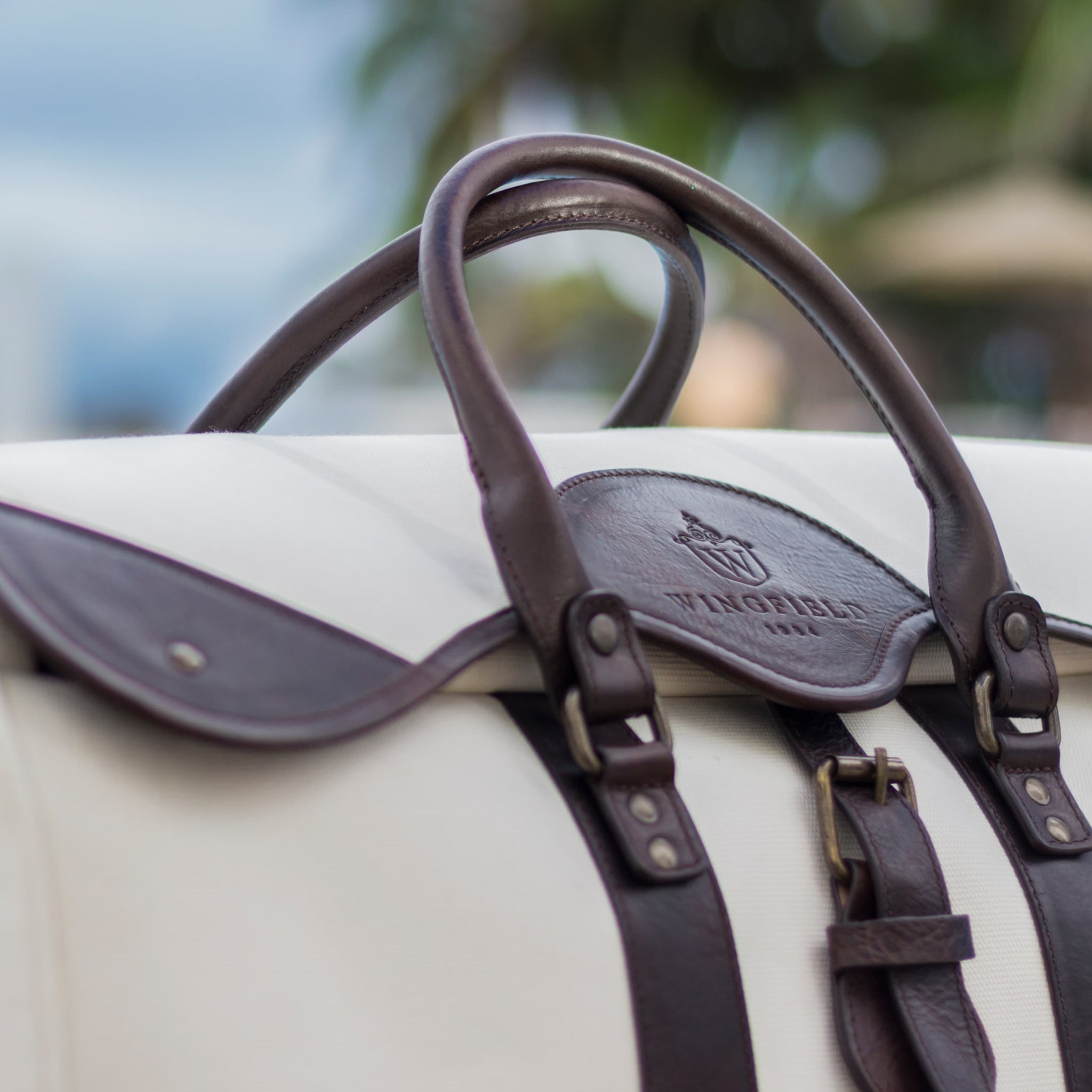 Large canvas and leather duffel bag with top handles, adjustable shoulder strap, leather trim, and zip closure, for travel