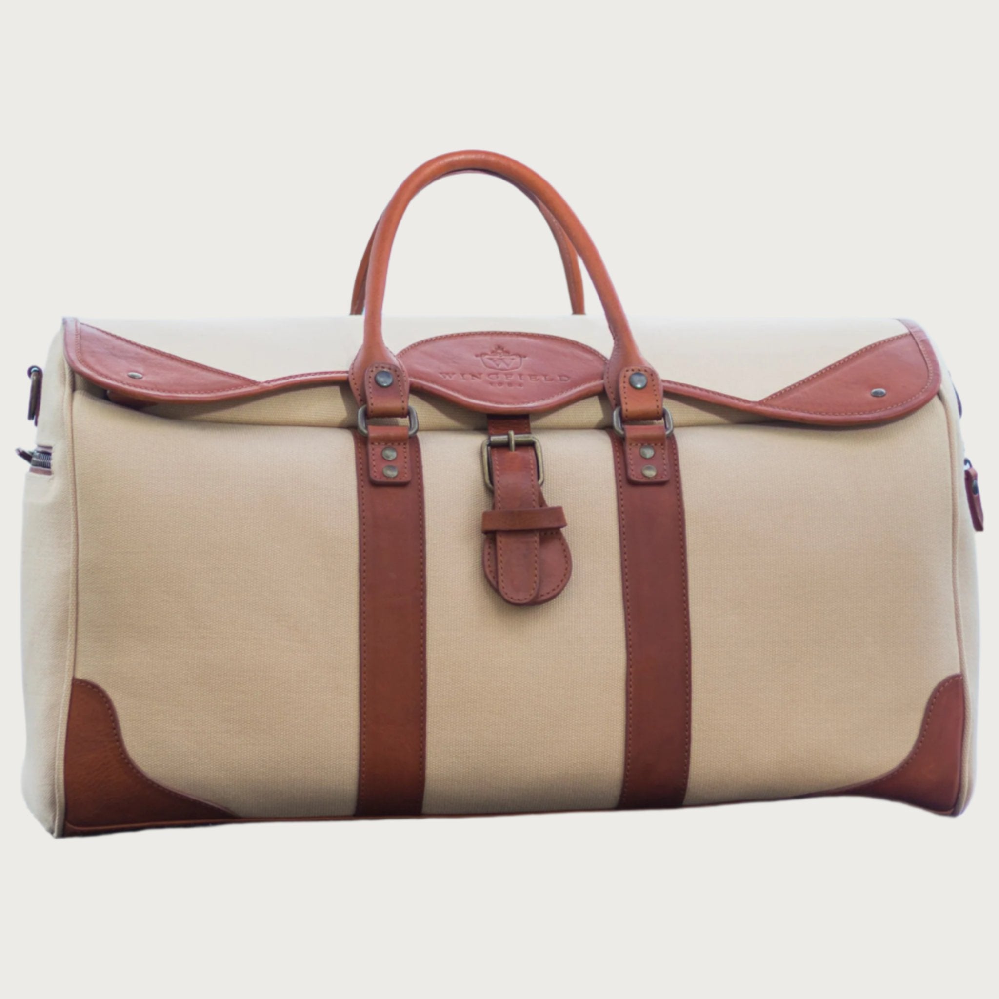 Large canvas and leather duffel bag with top handles, adjustable shoulder strap, leather trim, and zip closure, for travel