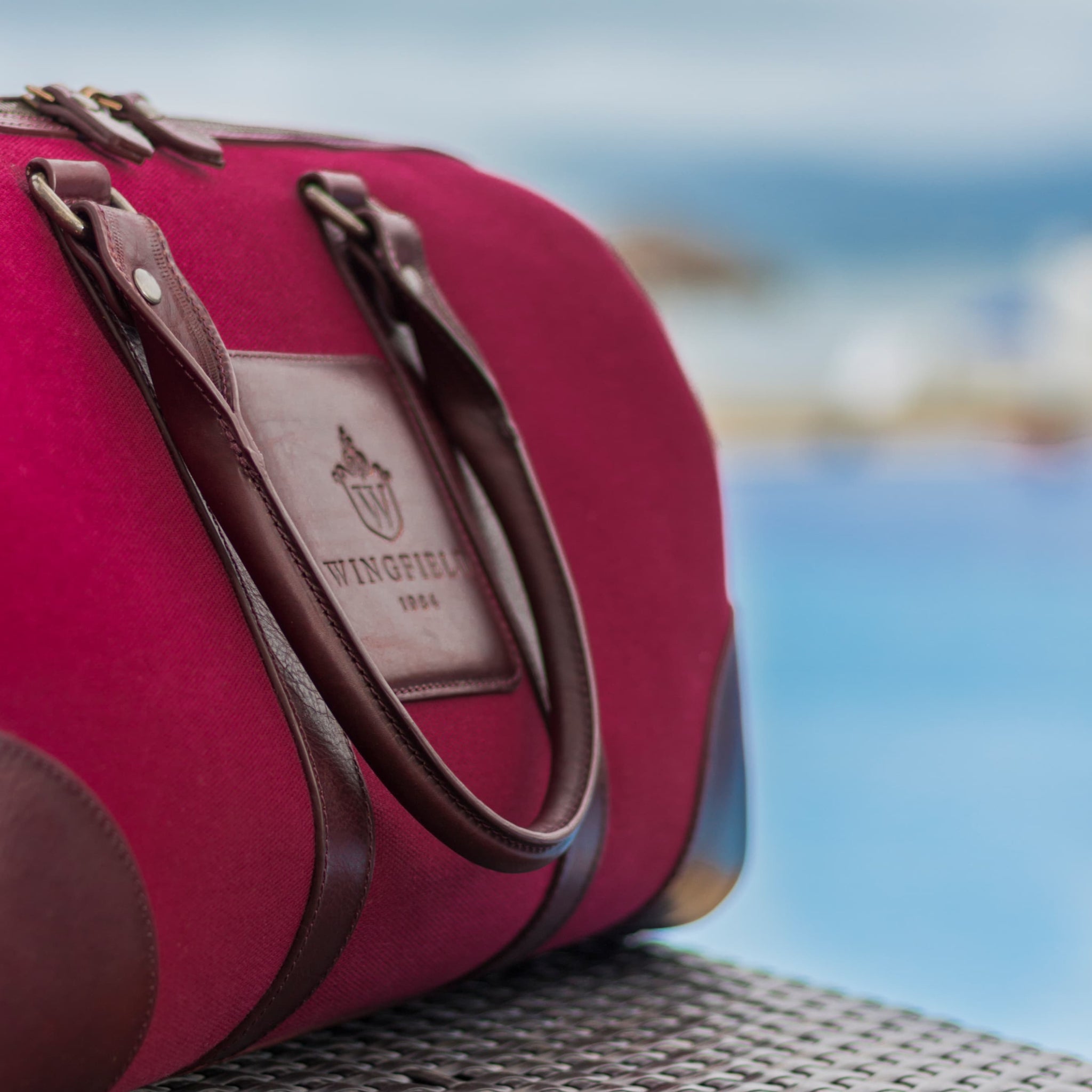 Compact canvas and leather duffel bag with top handles, adjustable shoulder strap, leather accents, zip closure travel ready