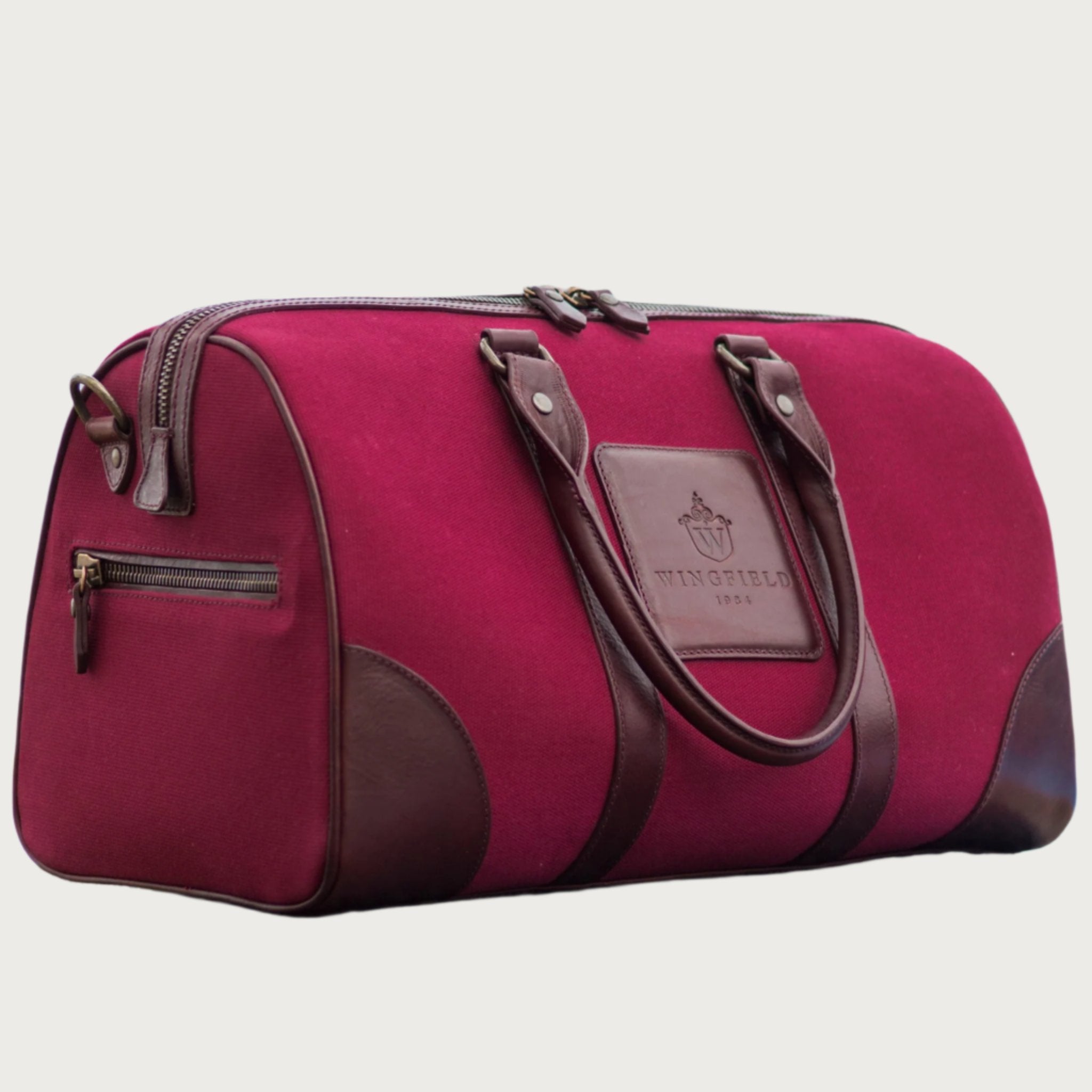 Compact canvas and leather duffel bag with top handles, adjustable shoulder strap, leather accents, zip closure travel ready