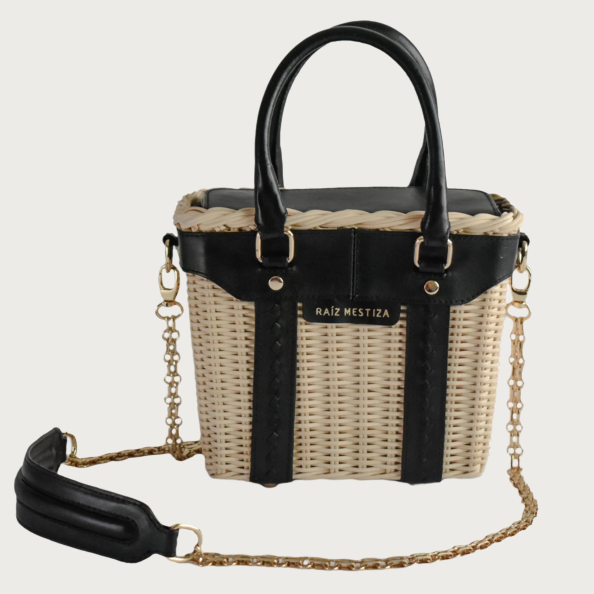 Leather and wicker tote bag with structured body, dual top handles, inner lining, and chain strap, elegant handcrafted feel