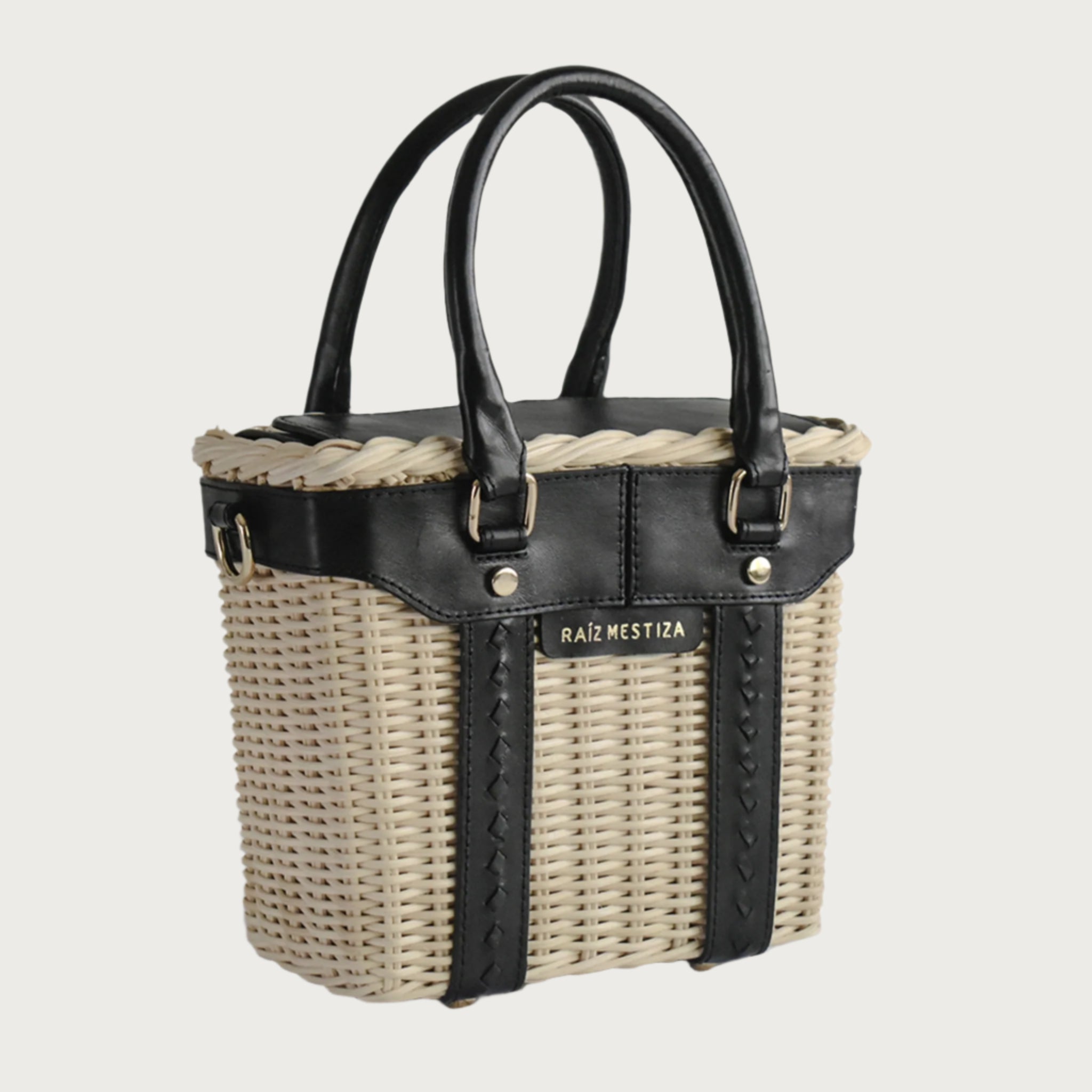 Leather and wicker tote bag with structured body, dual top handles, inner lining, and chain strap, elegant handcrafted feel