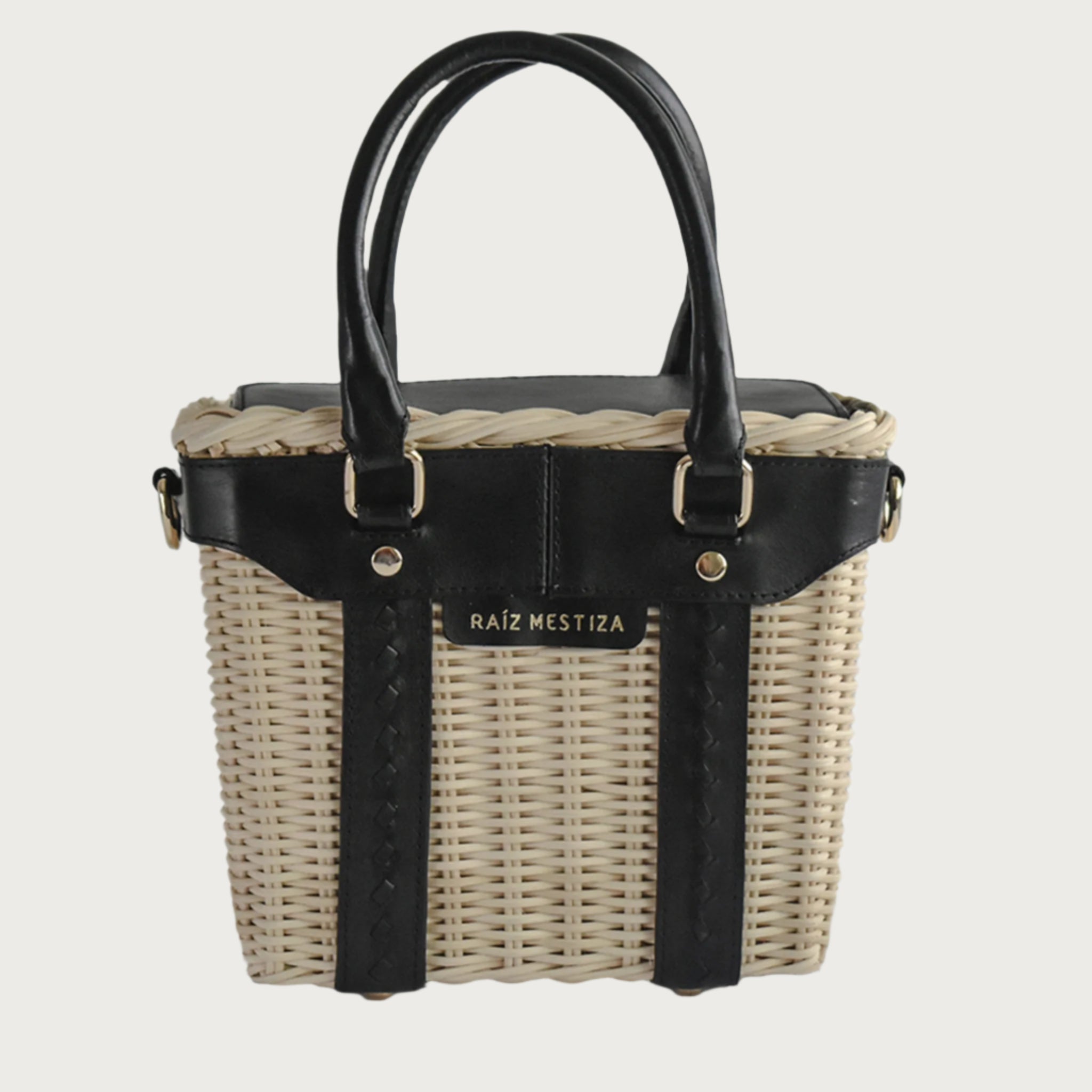 Leather and wicker tote bag with structured body, dual top handles, inner lining, and chain strap, elegant handcrafted feel