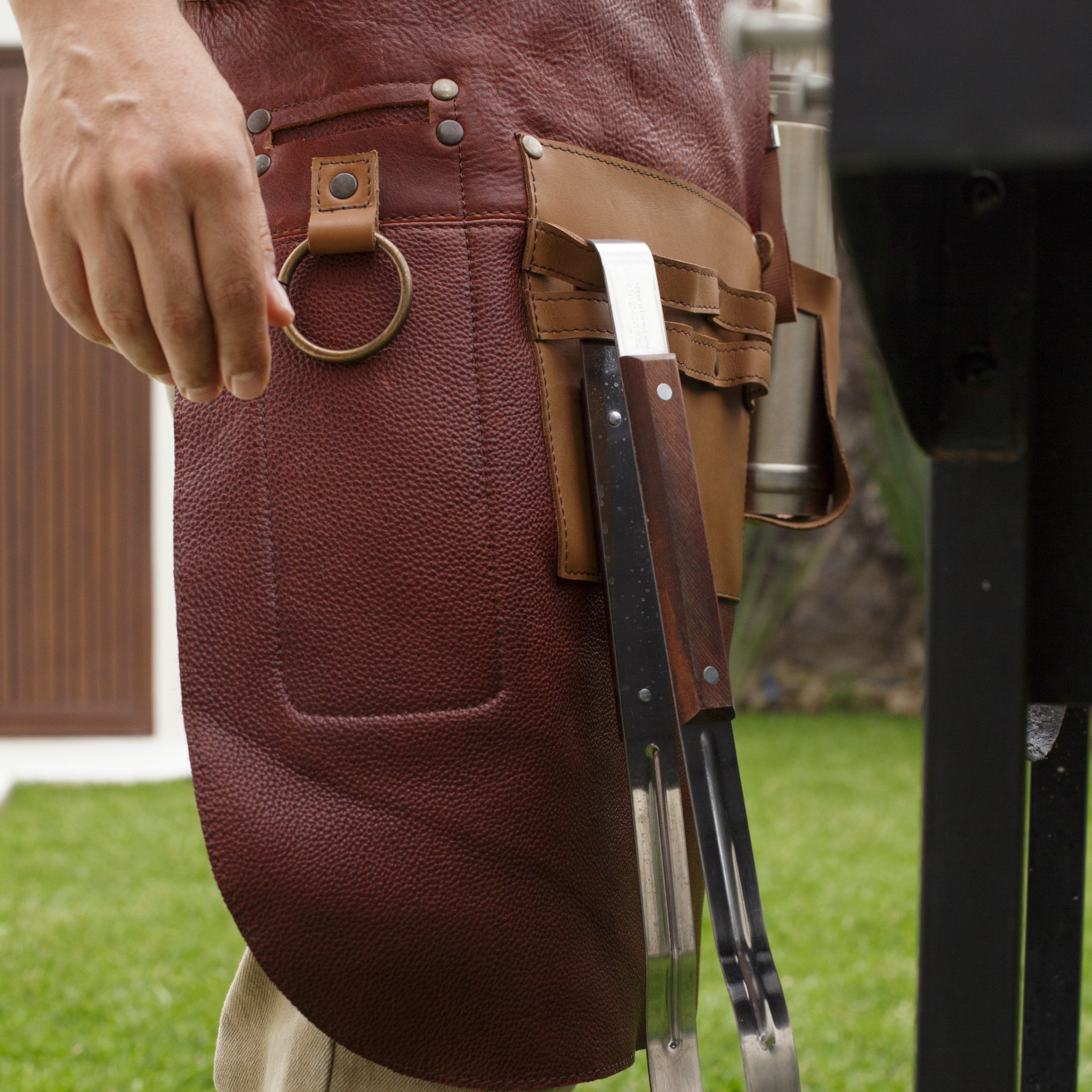 Full leather apron, adjustable straps, front chest pocket, tool loops, and rich texture, ideal for grilling, crafts, shop use