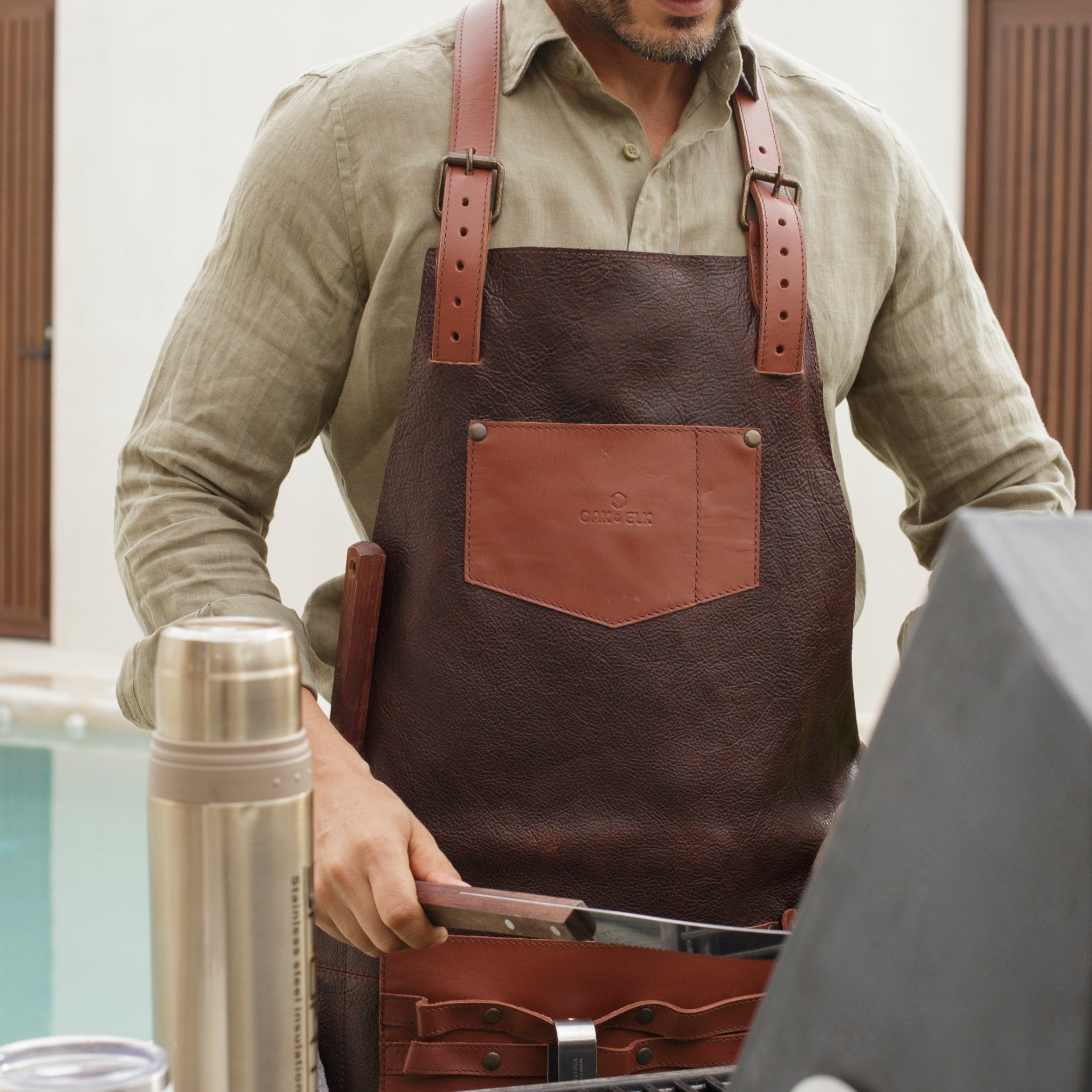 Full leather apron, adjustable straps, front chest pocket, tool loops, and rich texture, ideal for grilling, crafts, shop use
