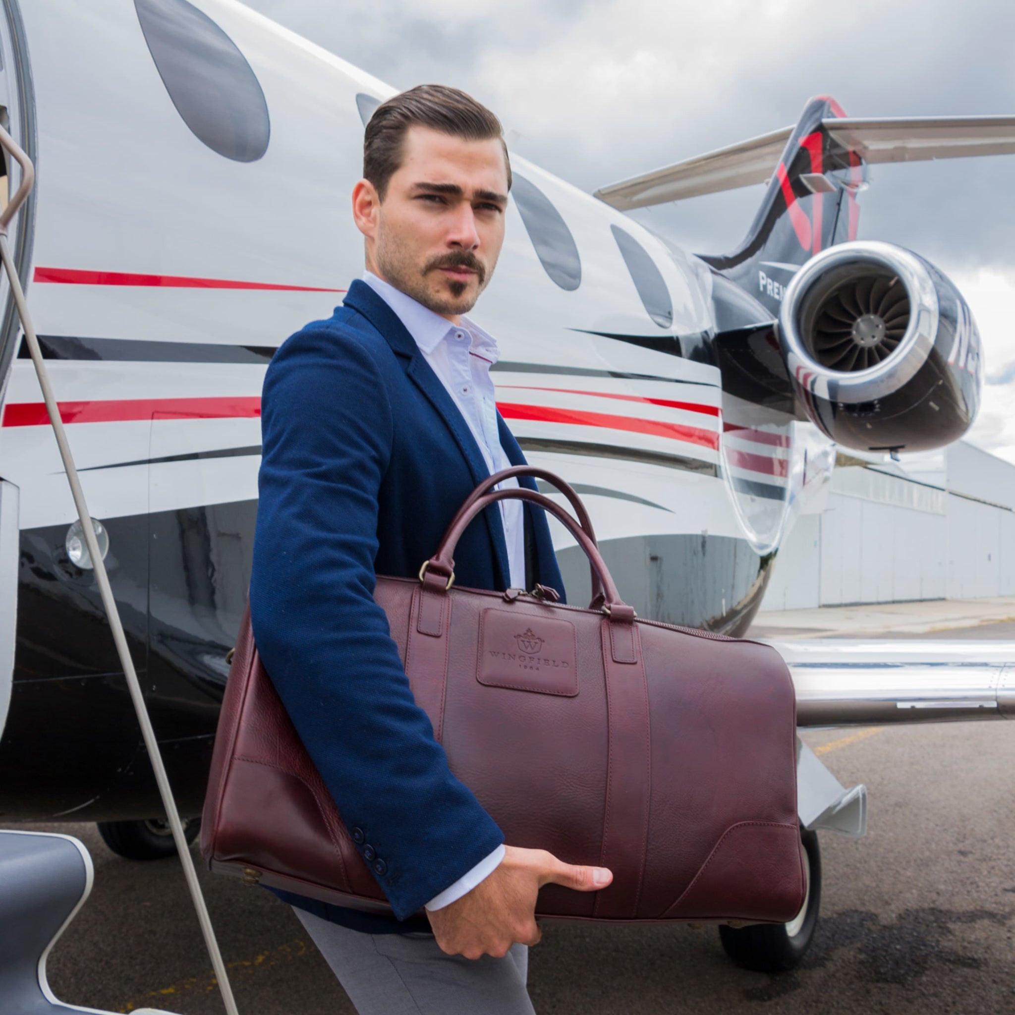 Large full-leather duffel bag with zip closure, structured body, carry handles, adjustable shoulder strap, ideal for travel.