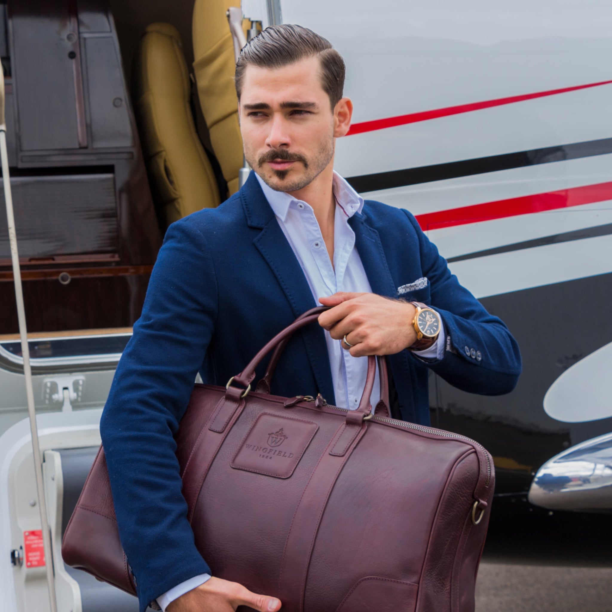 Large full-leather duffel bag with zip closure, structured body, carry handles, adjustable shoulder strap, ideal for travel.