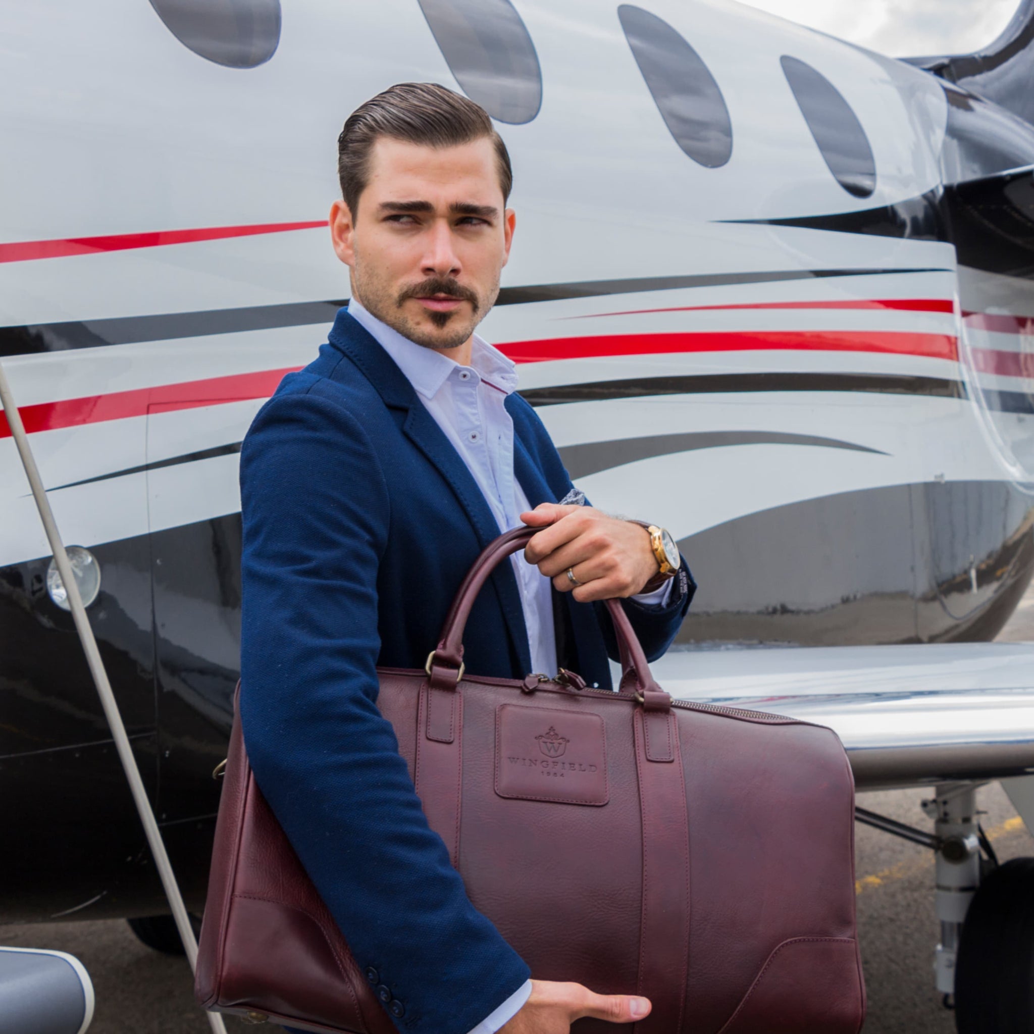 Large full-leather duffel bag with zip closure, structured body, carry handles, adjustable shoulder strap, ideal for travel.