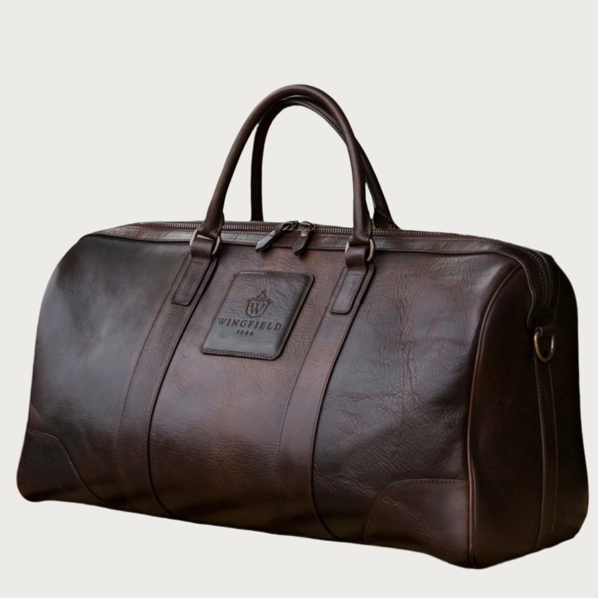 Large full-leather duffel bag with zip closure, structured body, carry handles, adjustable shoulder strap, ideal for travel.