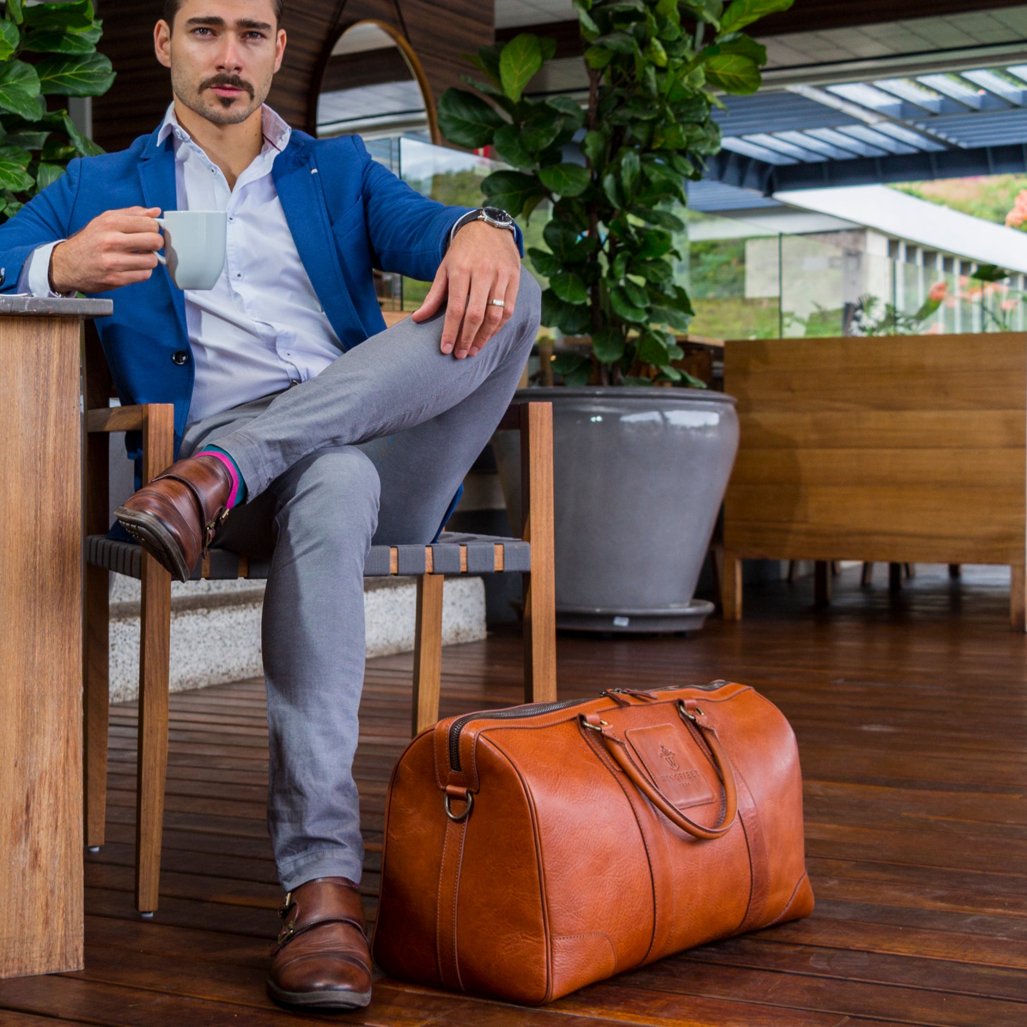 Large full-leather duffel bag with zip closure, structured body, carry handles, adjustable shoulder strap, ideal for travel.