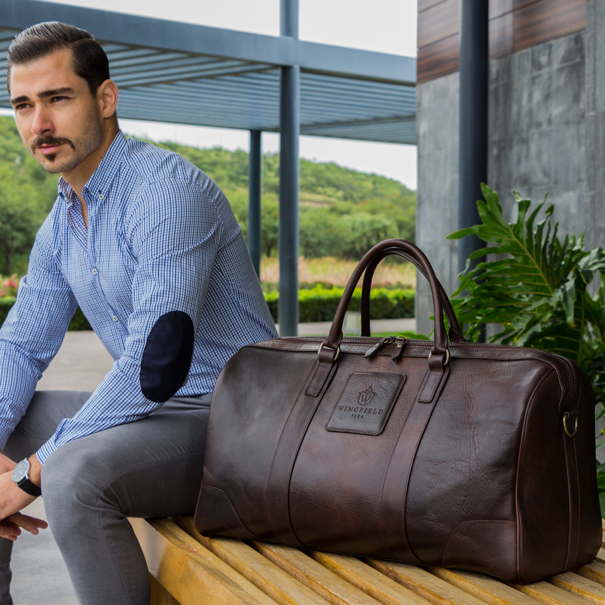 Large full-leather duffel bag with zip closure, structured body, carry handles, adjustable shoulder strap, ideal for travel.