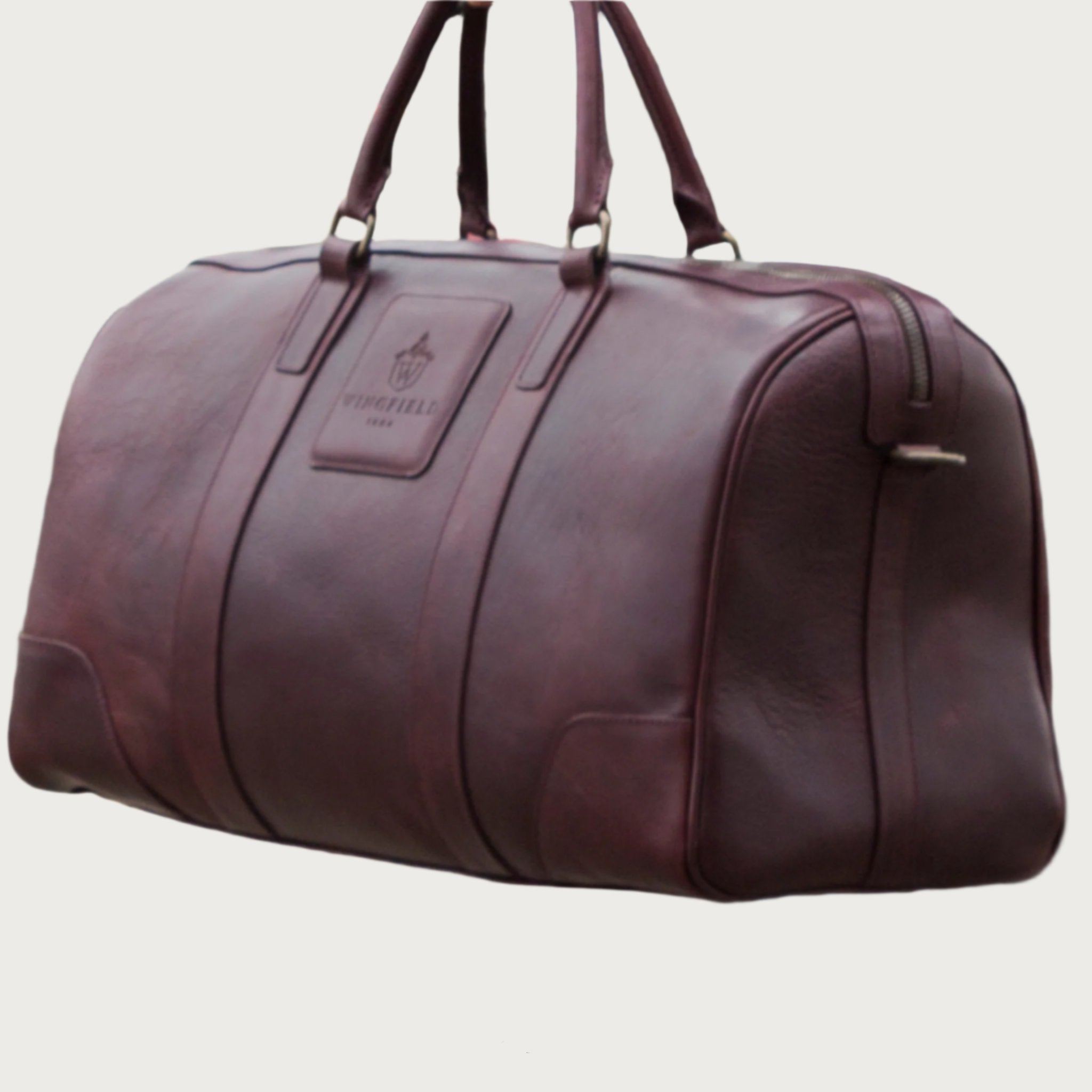 Large full-leather duffel bag with zip closure, structured body, carry handles, adjustable shoulder strap, ideal for travel.