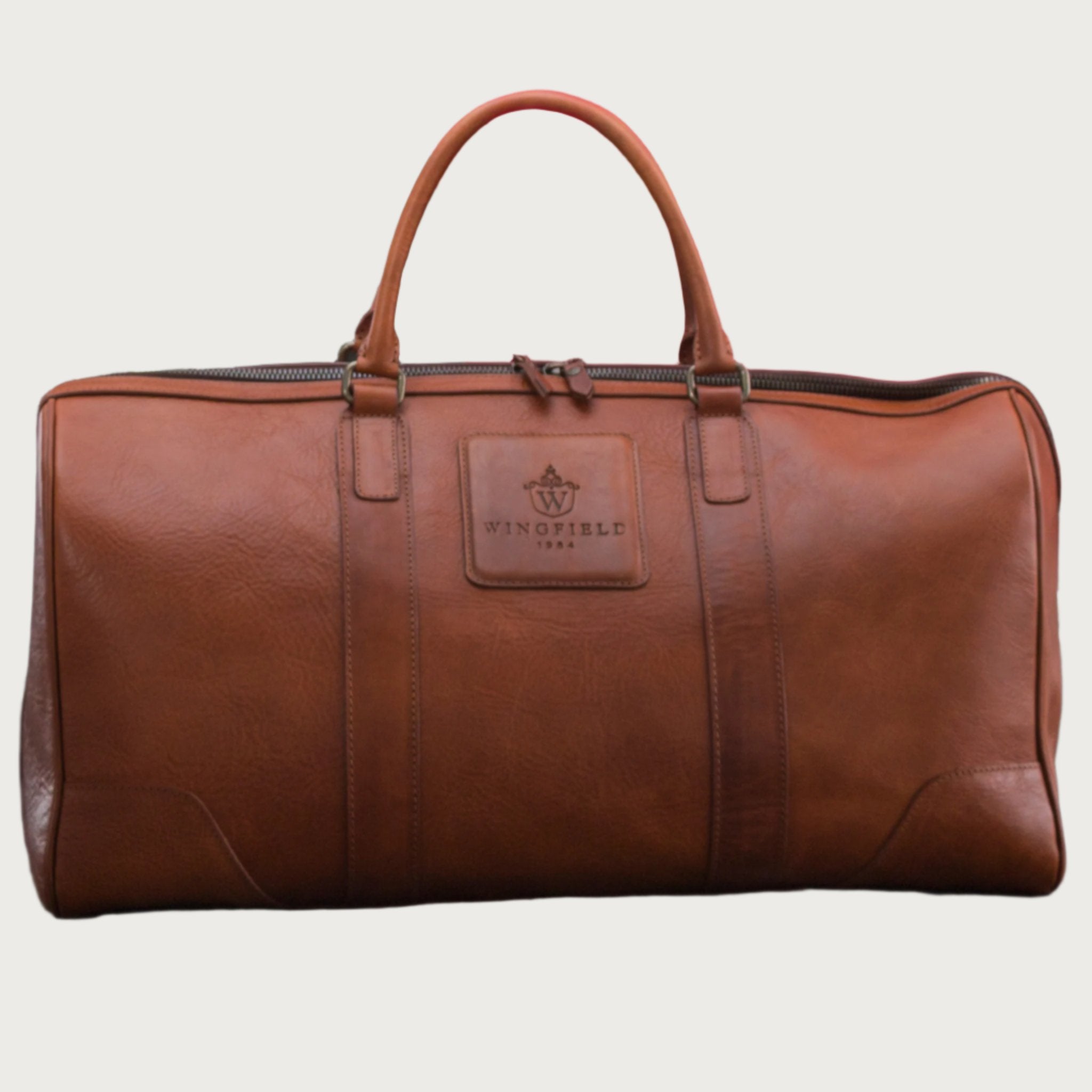 Large full-leather duffel bag with zip closure, structured body, carry handles, adjustable shoulder strap, ideal for travel.