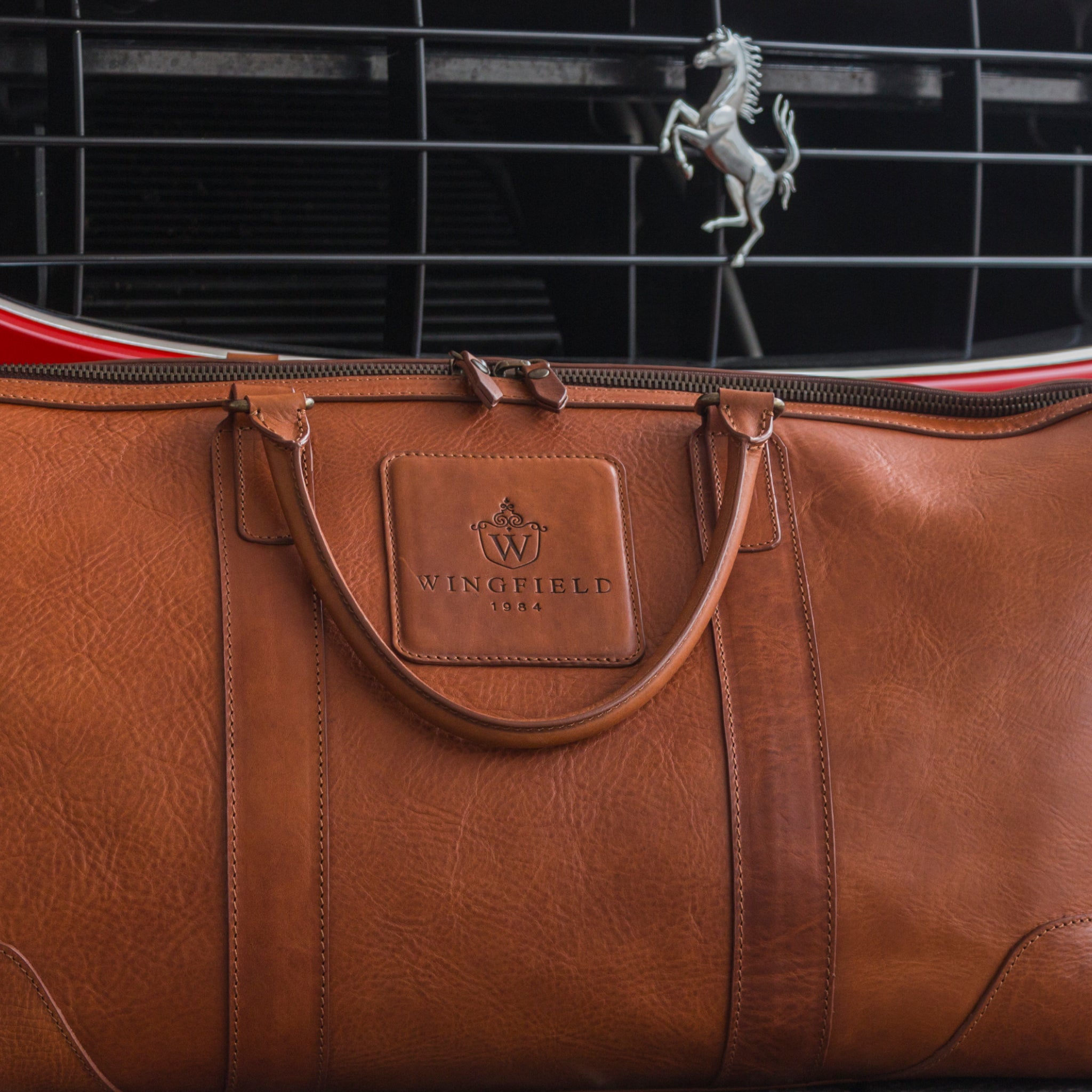 Large full-leather duffel bag with zip closure, structured body, carry handles, adjustable shoulder strap, ideal for travel.