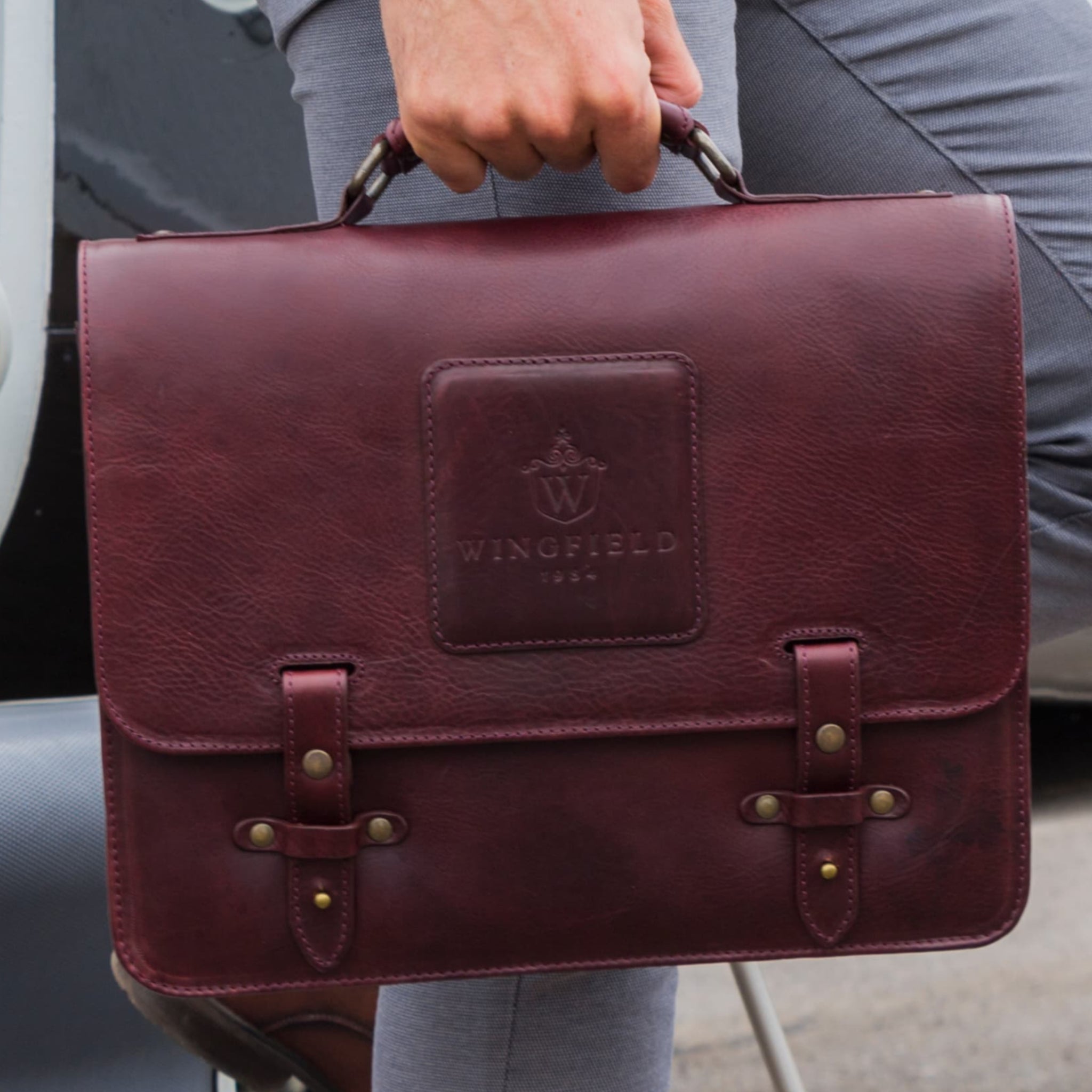 Leather messenger bag with flap closure, buckle details, adjustable strap, and slim profile — ideal for work or travel.