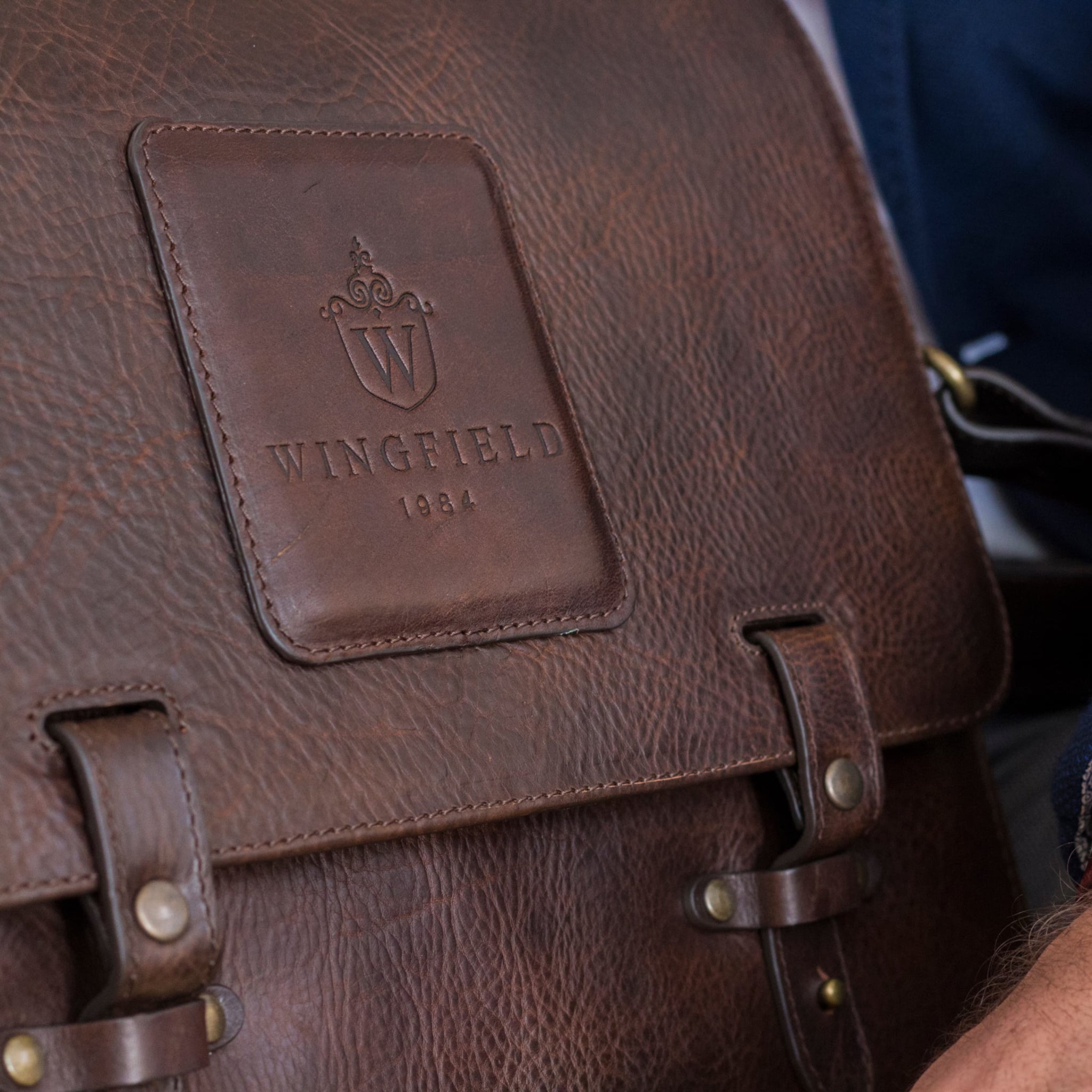Leather messenger bag with flap closure, buckle details, adjustable strap, and slim profile — ideal for work or travel.