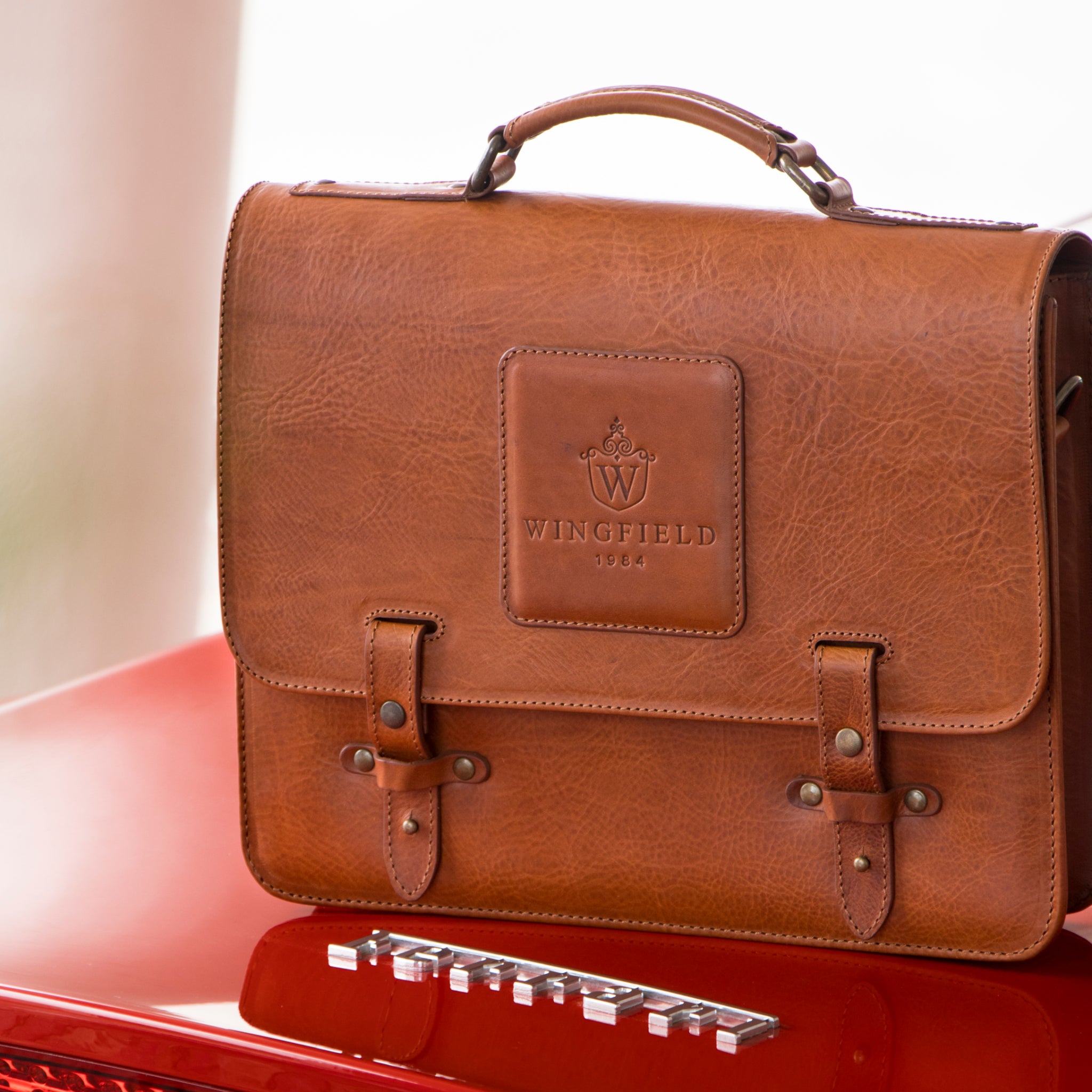 Leather messenger bag with flap closure, buckle details, adjustable strap, and slim profile — ideal for work or travel.