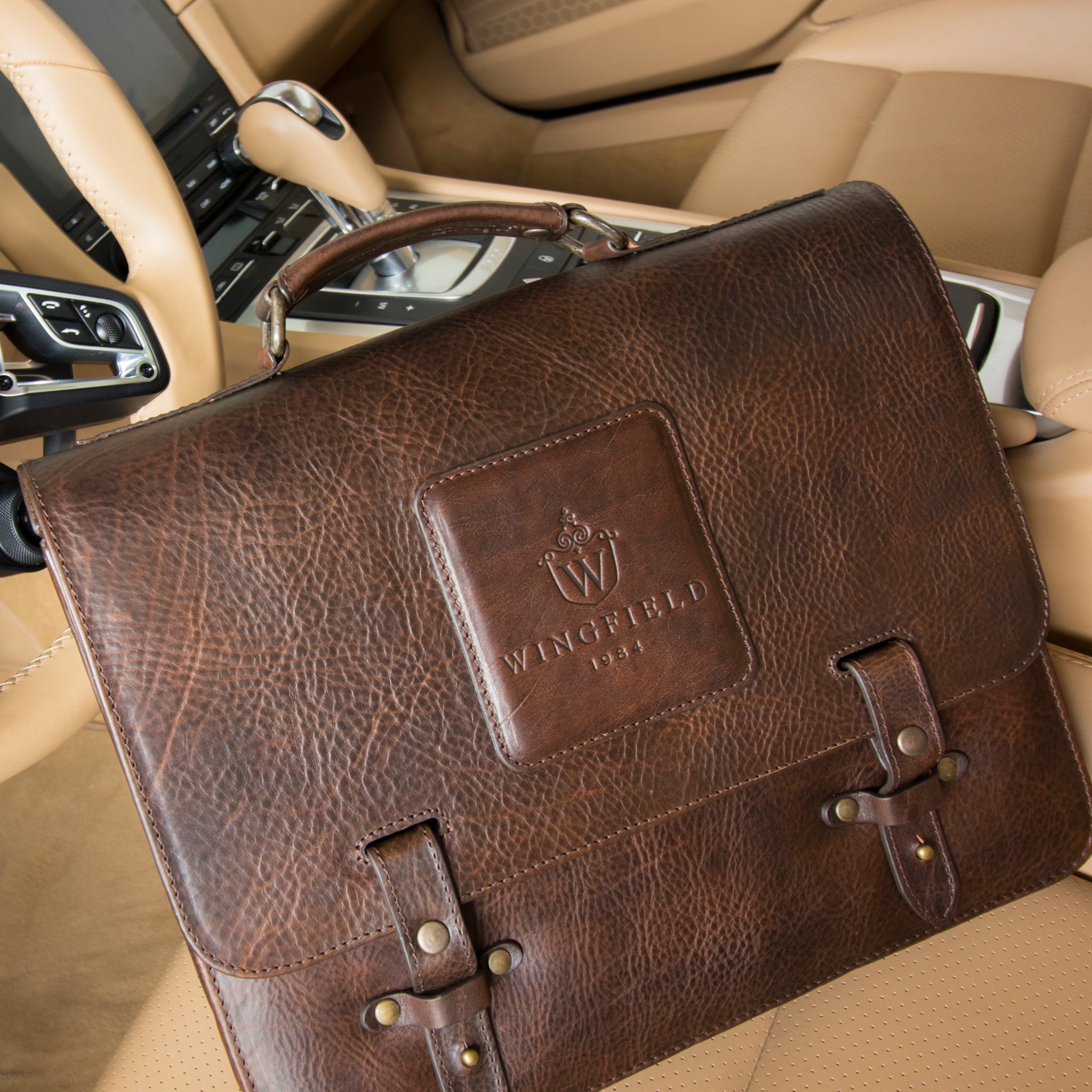 Leather messenger bag with flap closure, buckle details, adjustable strap, and slim profile — ideal for work or travel.