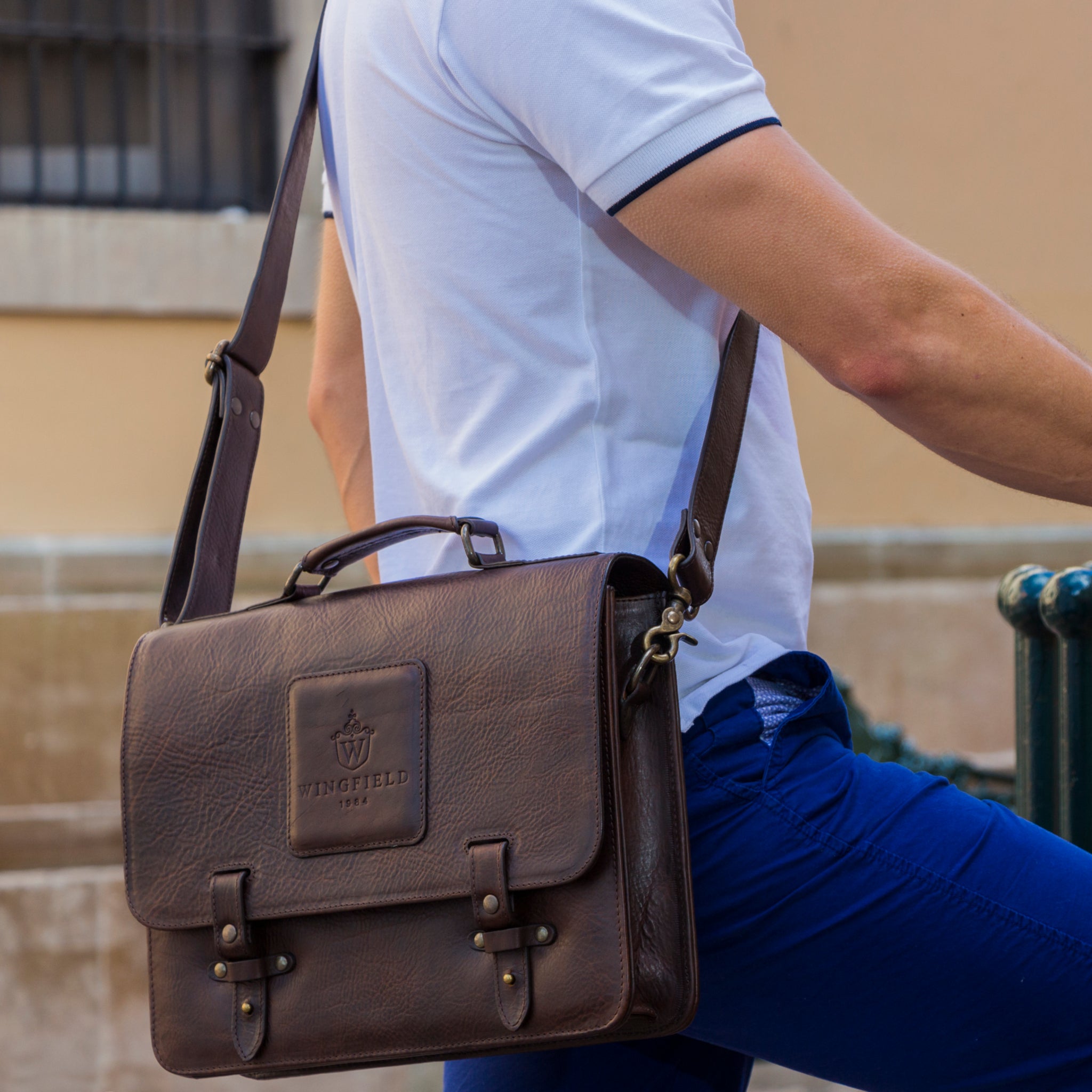 Leather messenger bag with flap closure, buckle details, adjustable strap, and slim profile — ideal for work or travel.