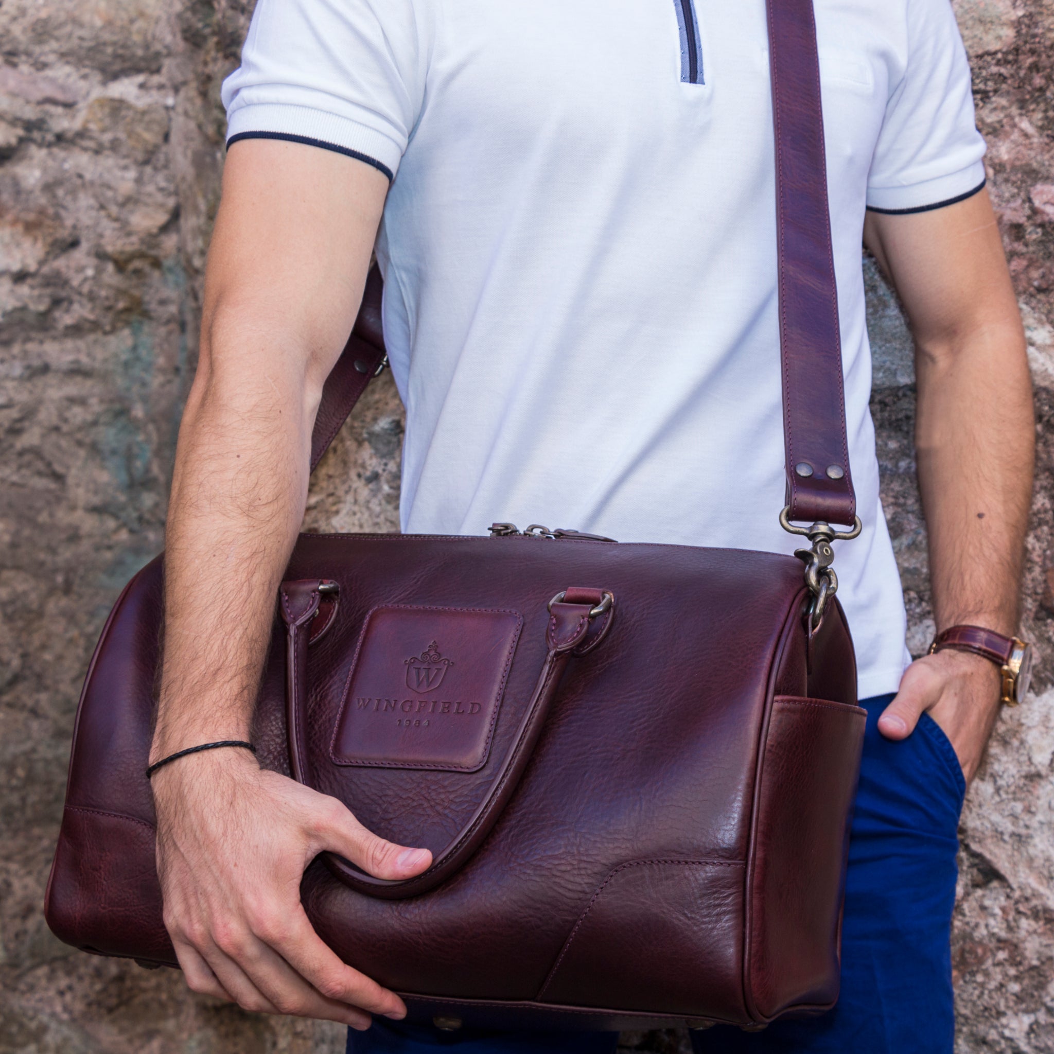 Full-grain leather duffel bag with zip closure, structured shape, carry handles, and adjustable shoulder strap, compact sleek