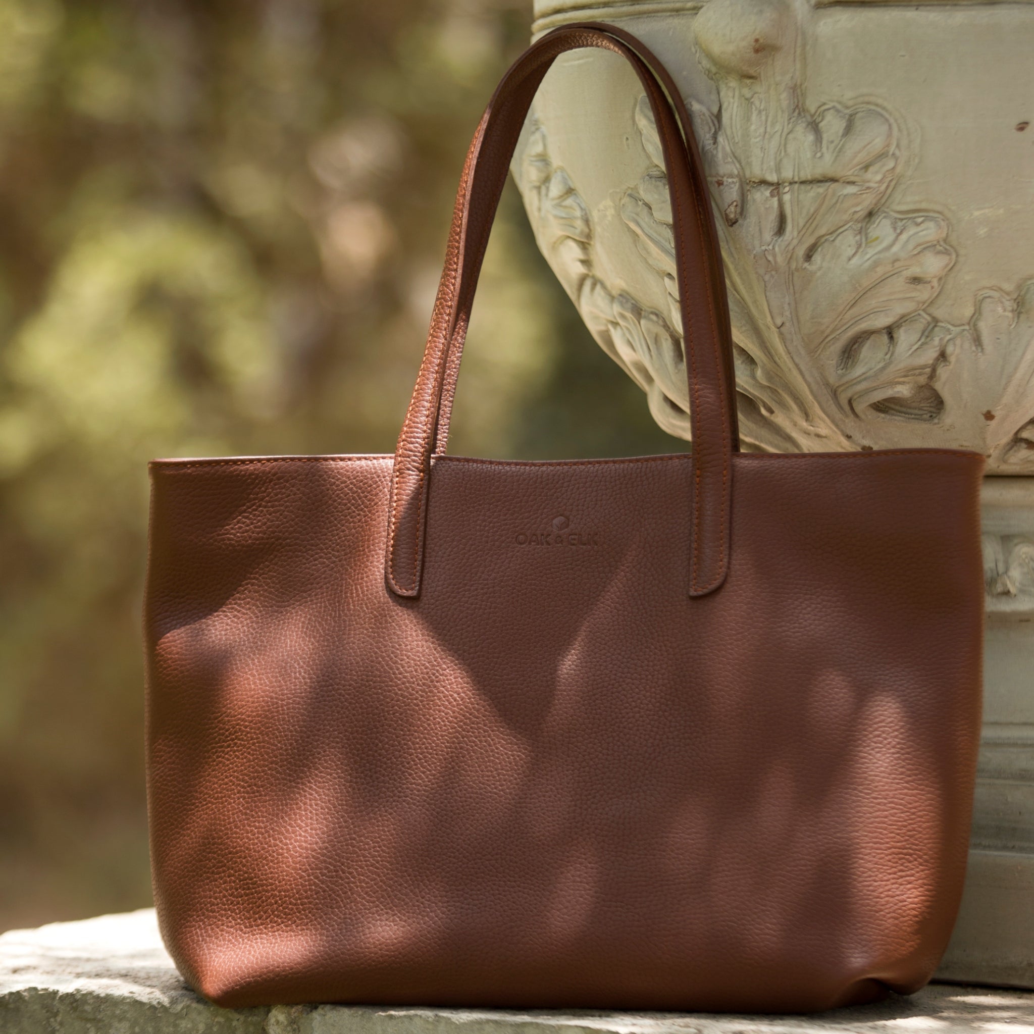 Leather tote made from top-grain leather, featuring smooth golden zipper, inner pouch, and structured design for daily use.
